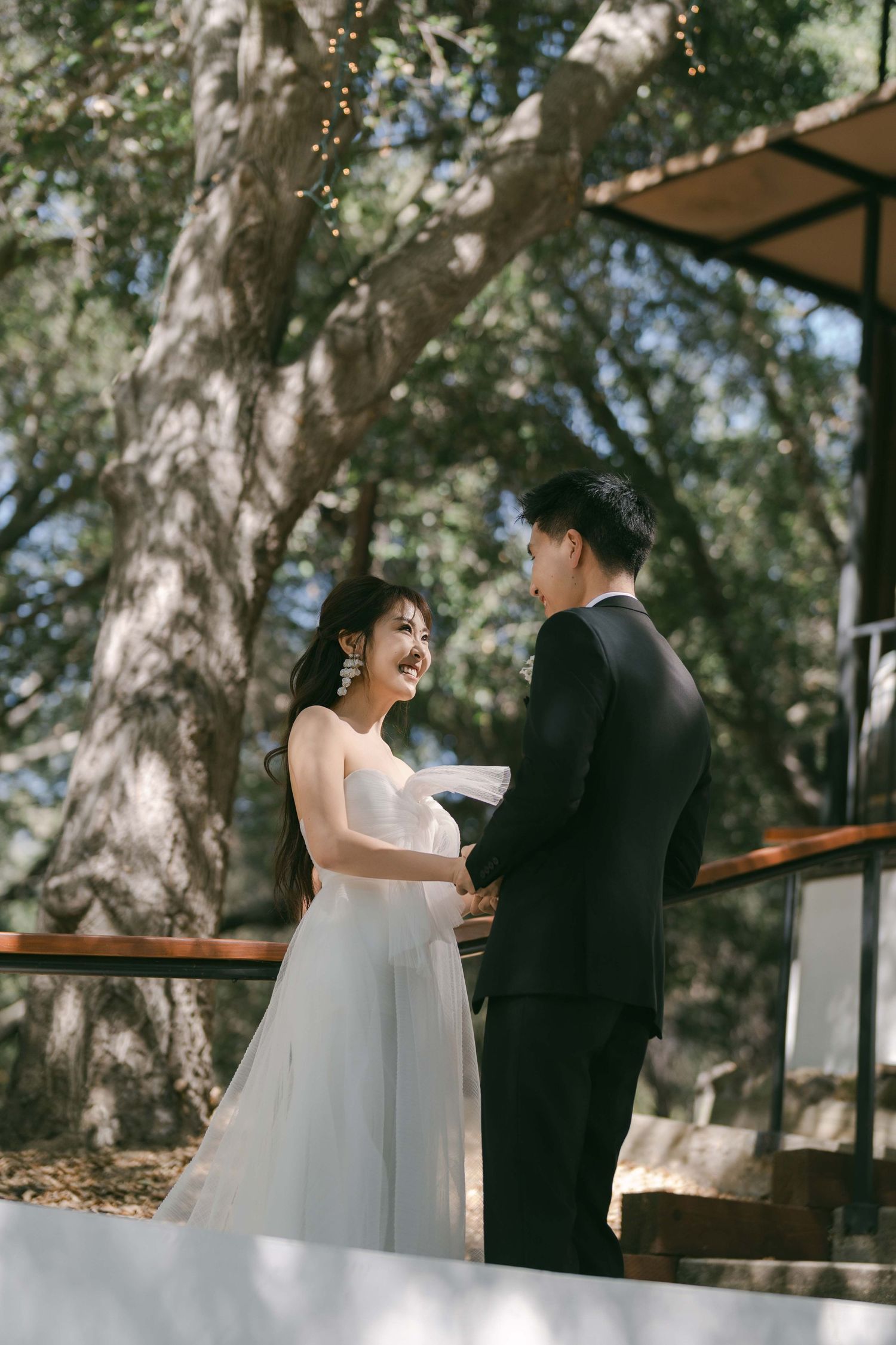 Wedding ceremony moment captured under natural tree canopy.