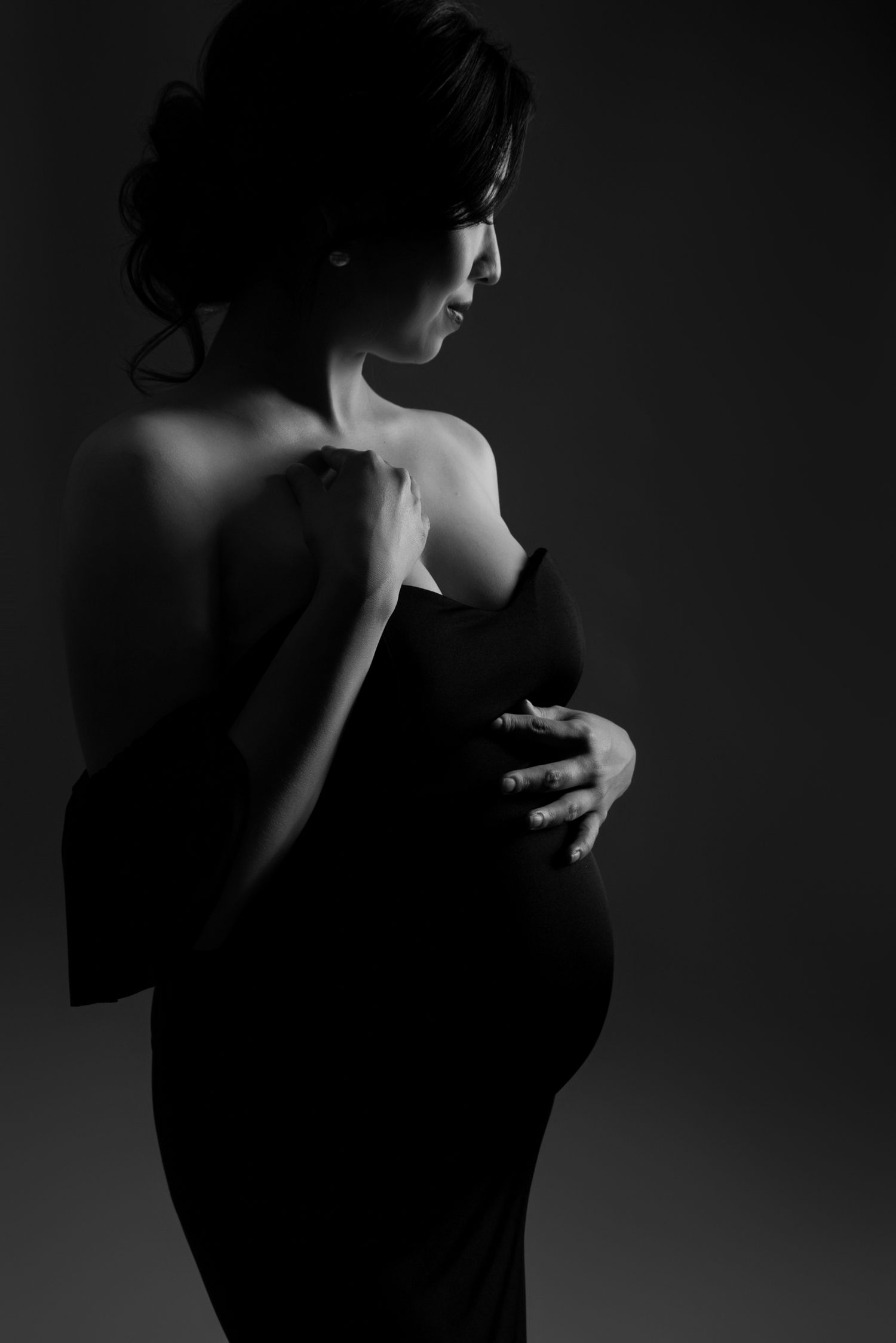 Dramatic low-key portrait series with dark shadows and highlights.