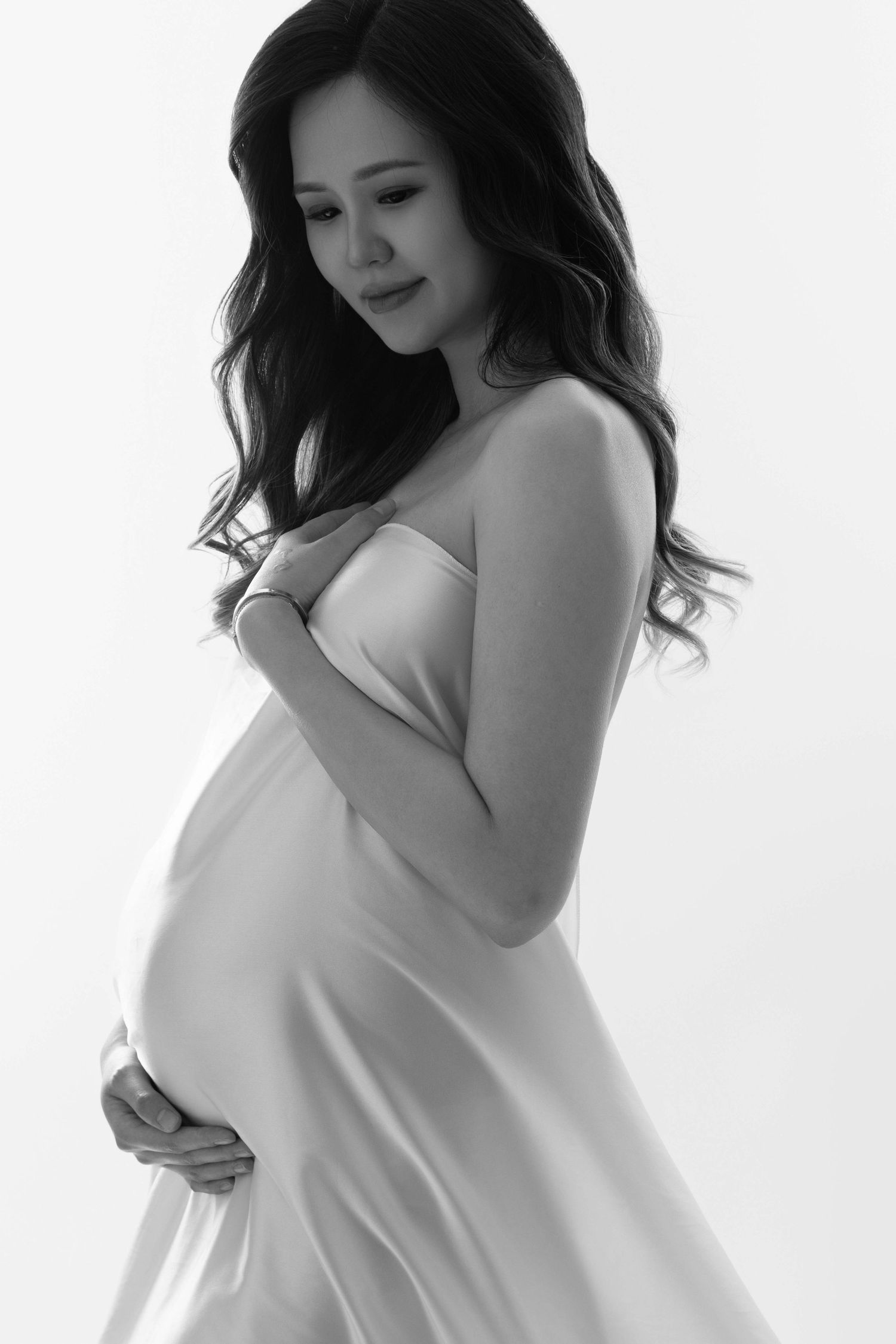 Black and white maternity photography series with soft natural poses.