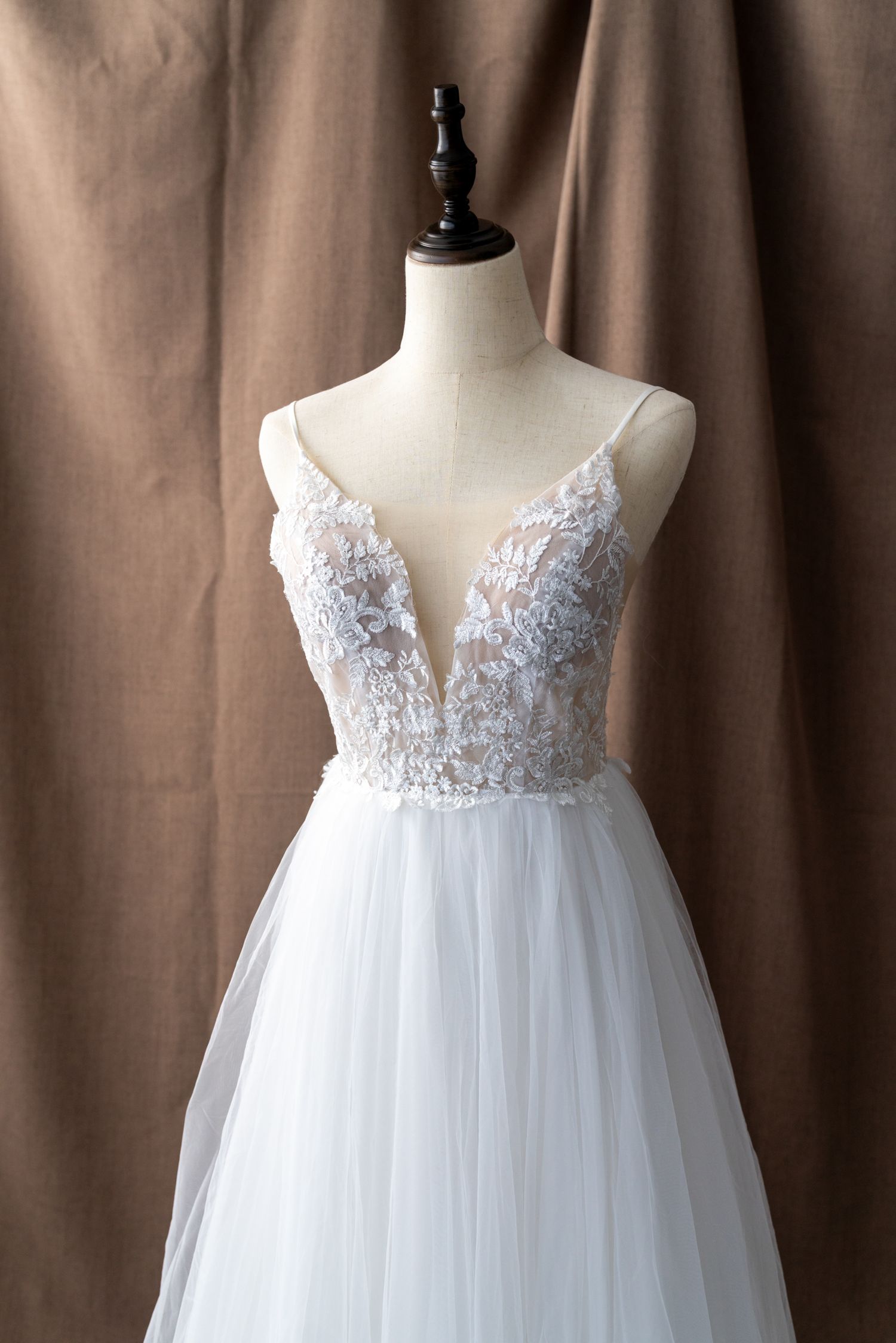 Romantic wedding gown featuring sheer lace bodice and flowing tulle skirt on display.