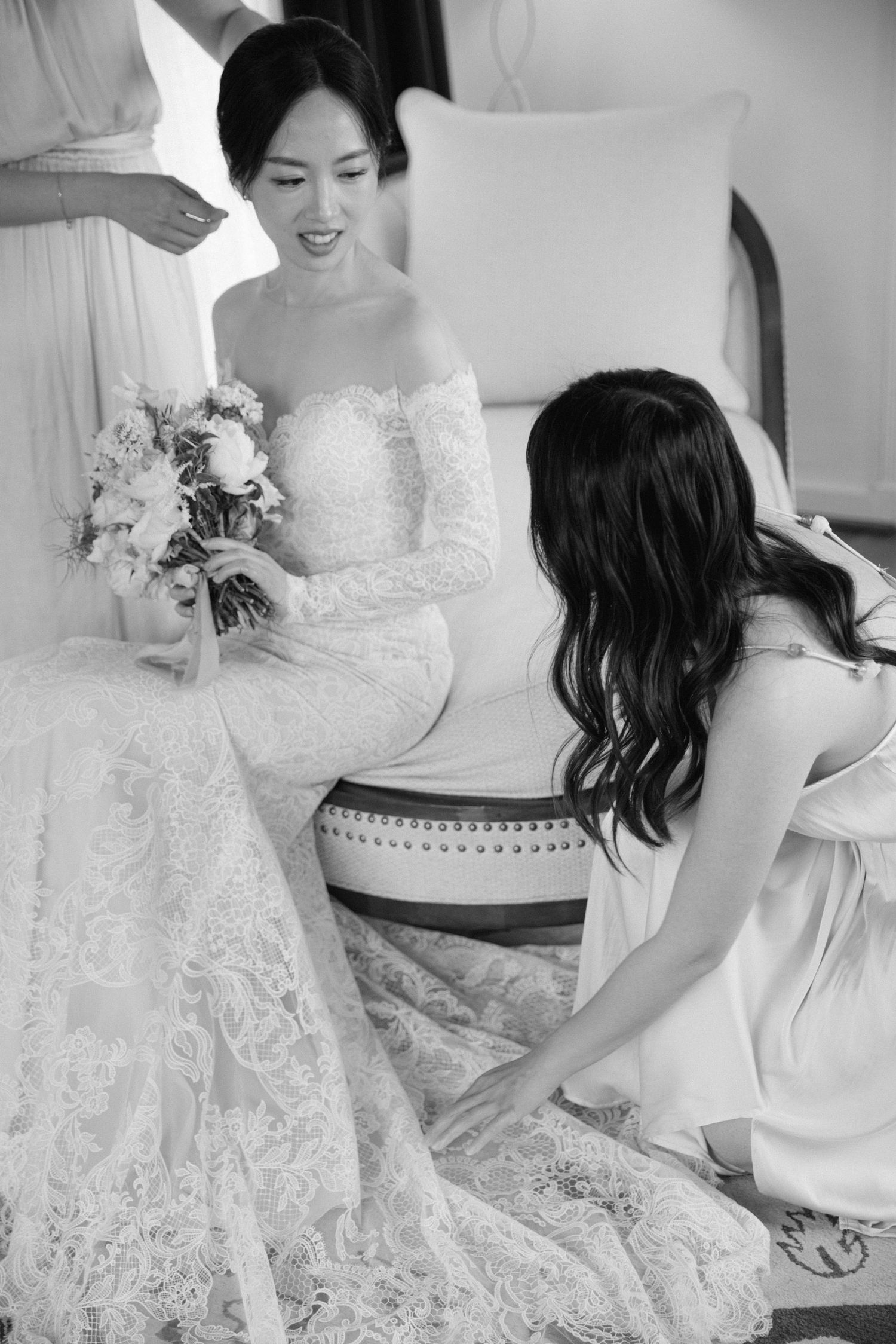 Black and white series showing intricate details of a lace wedding gown during bridal preparation.
