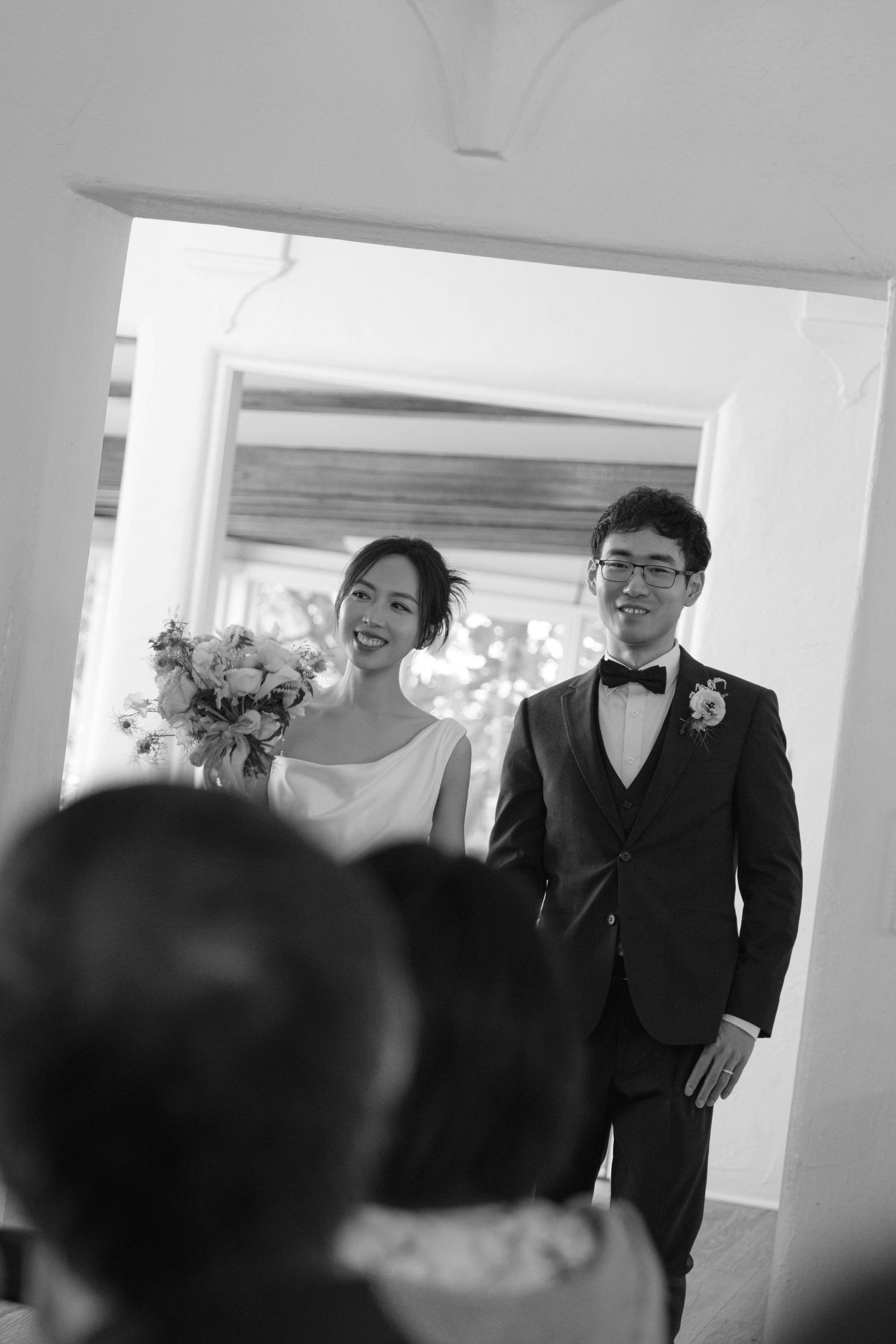 A joyful moment captured in black and white during a formal wedding ceremony.