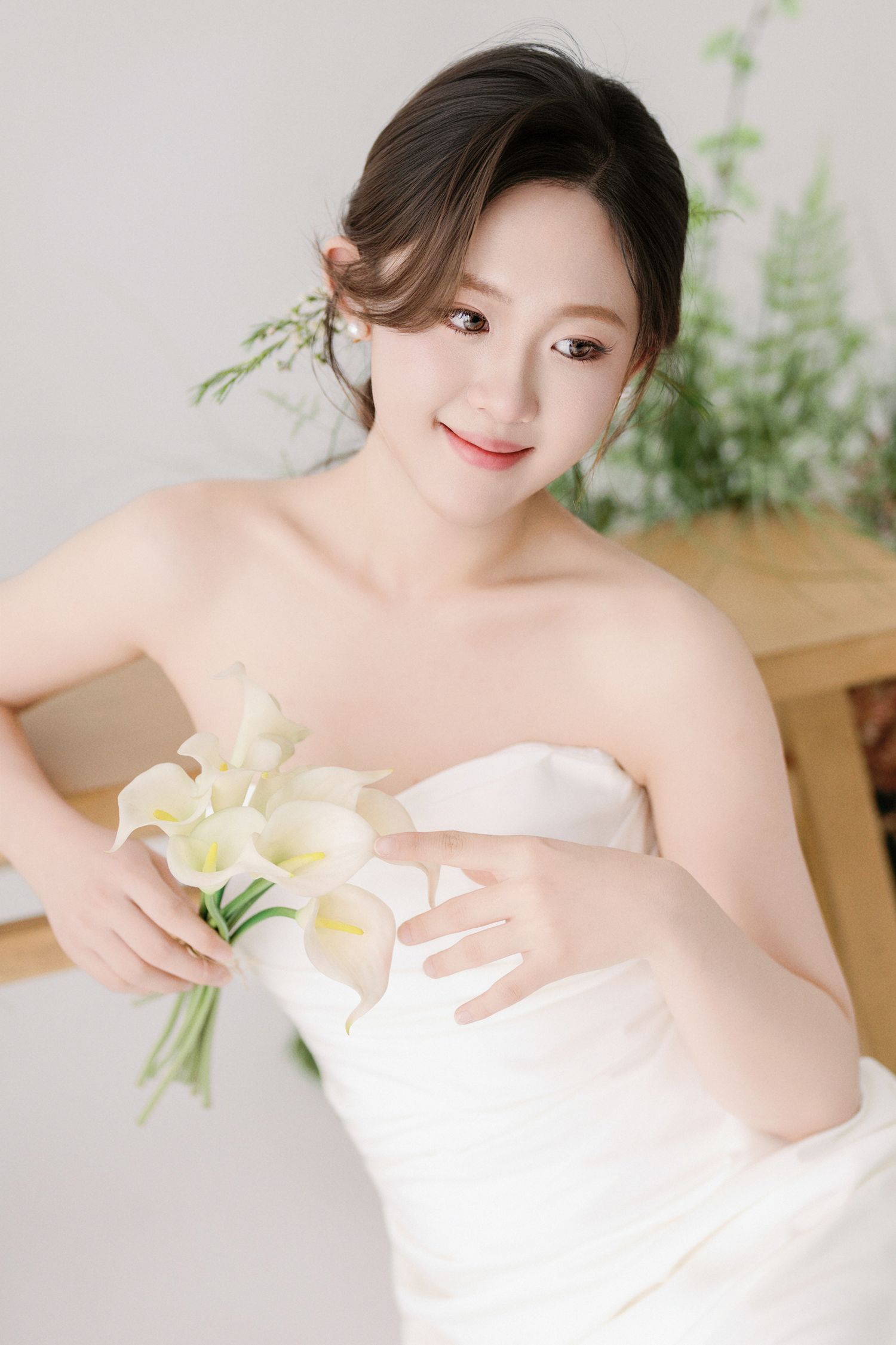 Intimate bridal portrait series with white lilies and delicate fabric details.