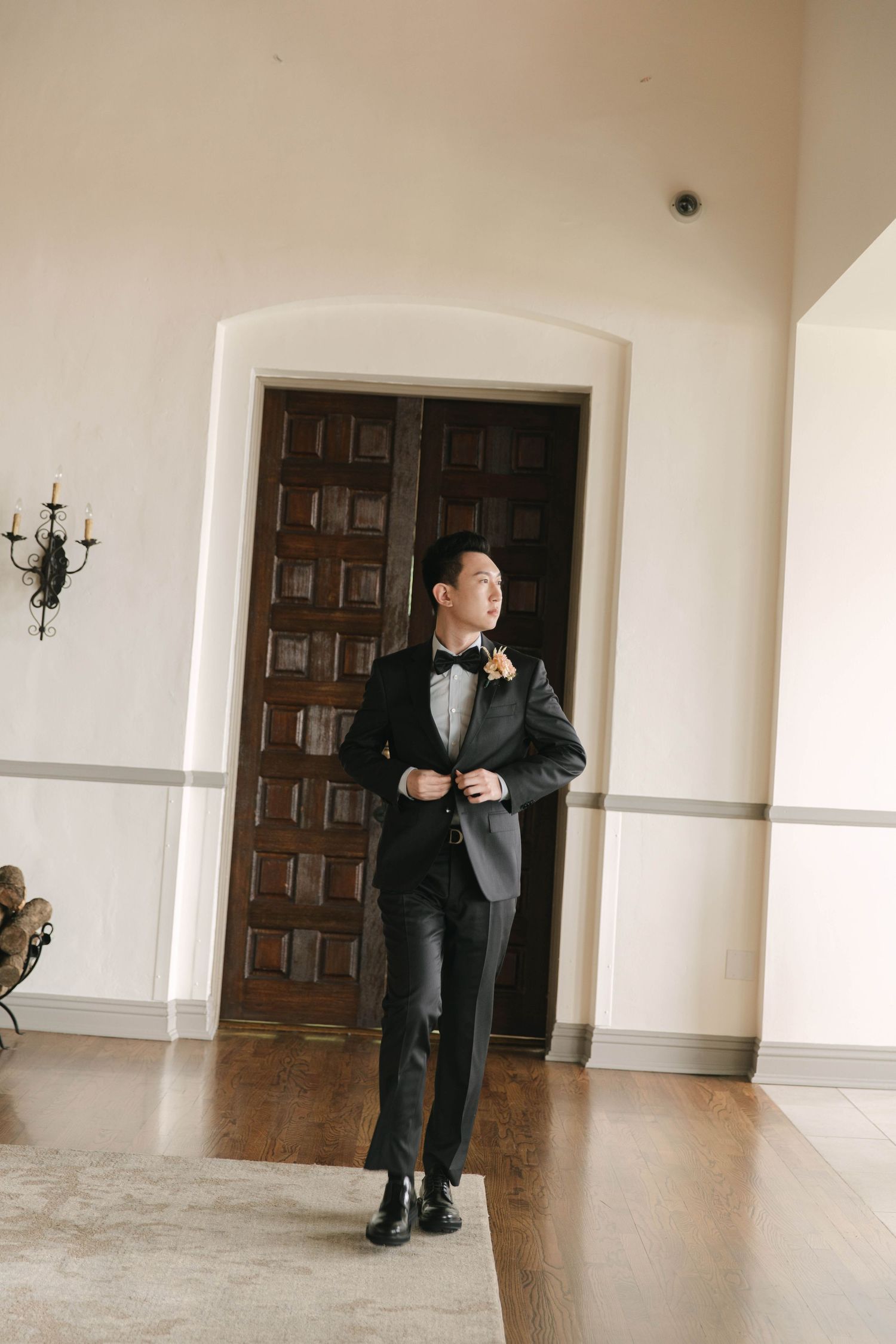 Wedding photography session in an elegant room with wooden doors and cream walls.