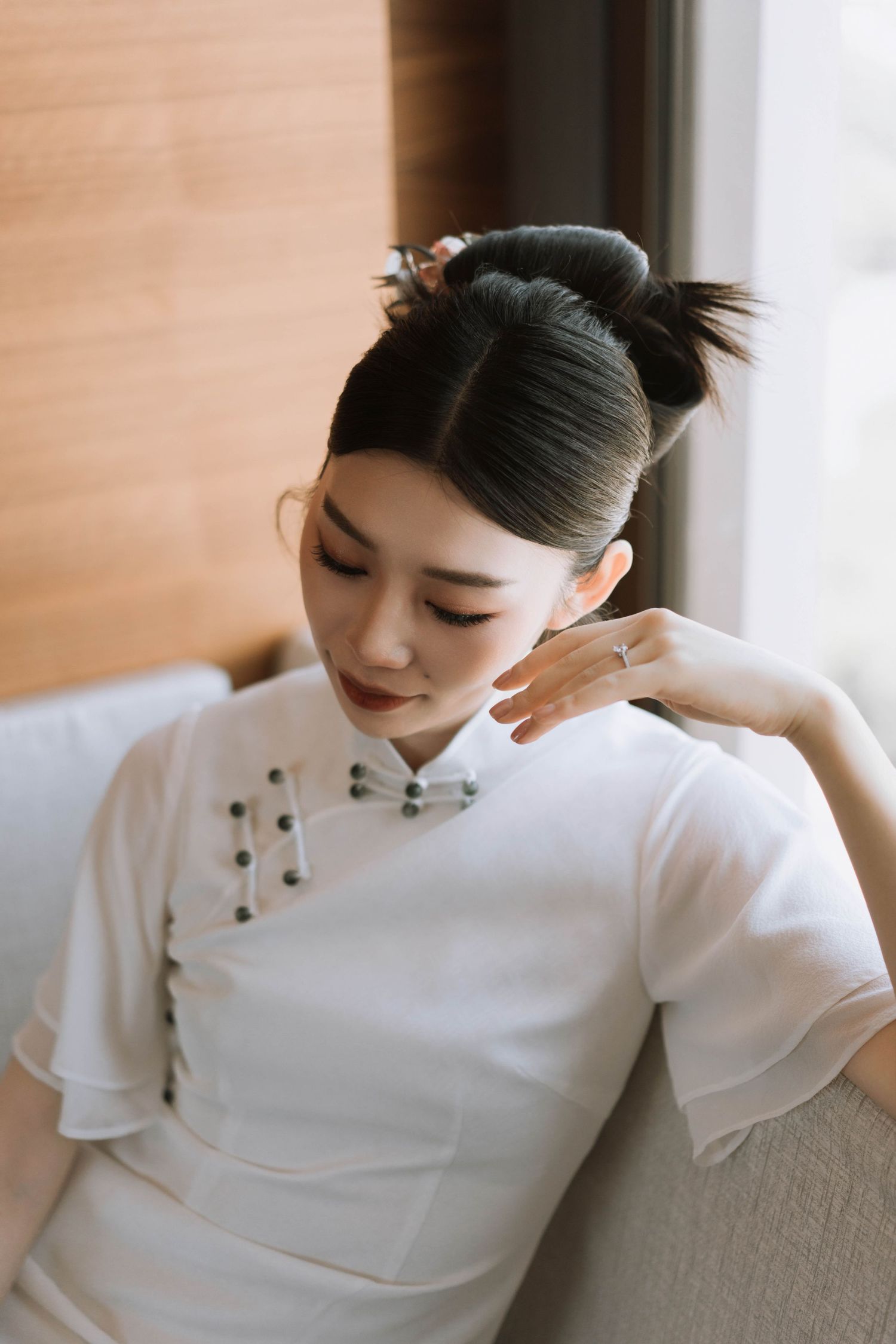 Intimate bridal portraits on a cream couch showing details of traditional Chinese dress.