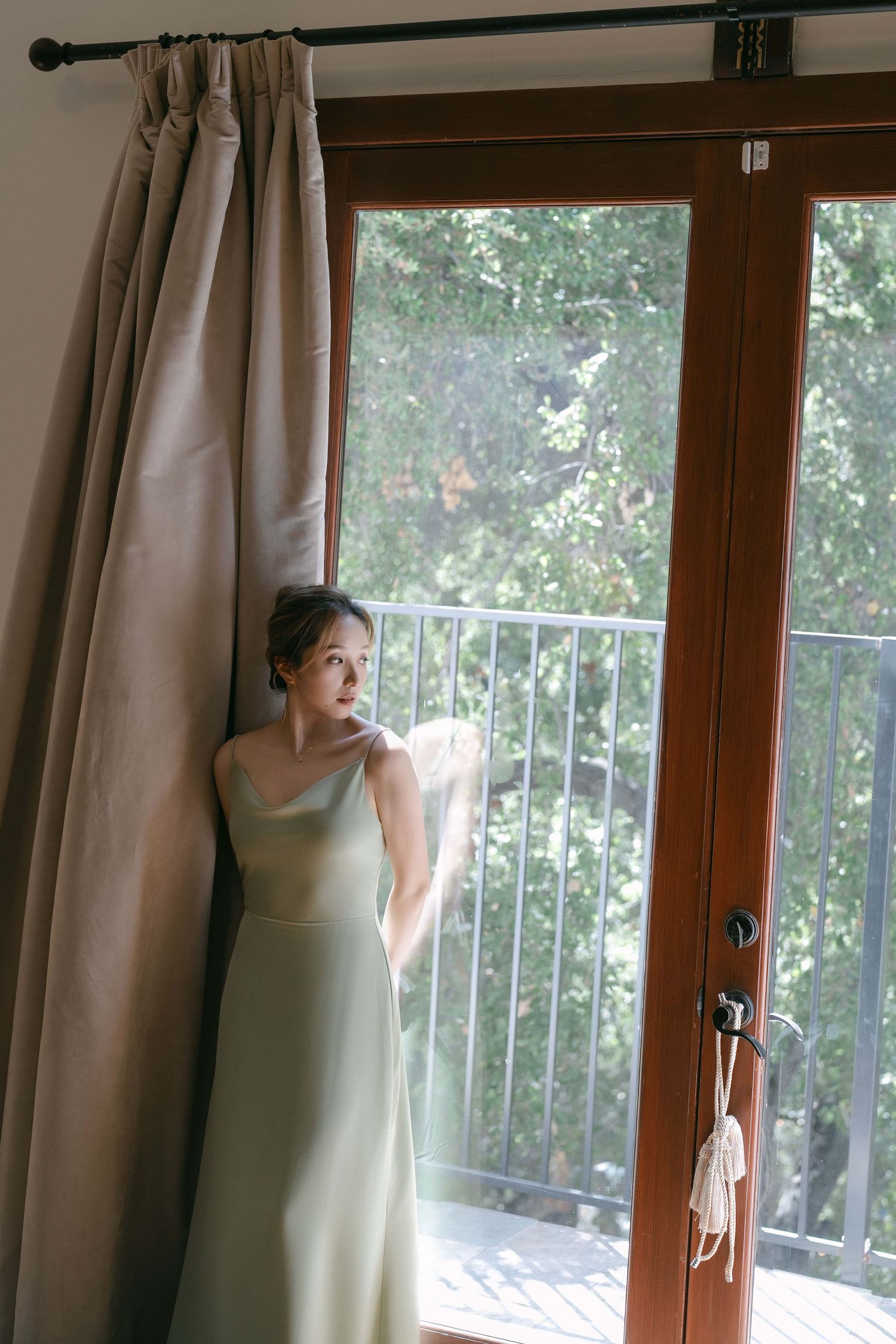 Light filters through curtained windows in an elegant room with wooden trim.