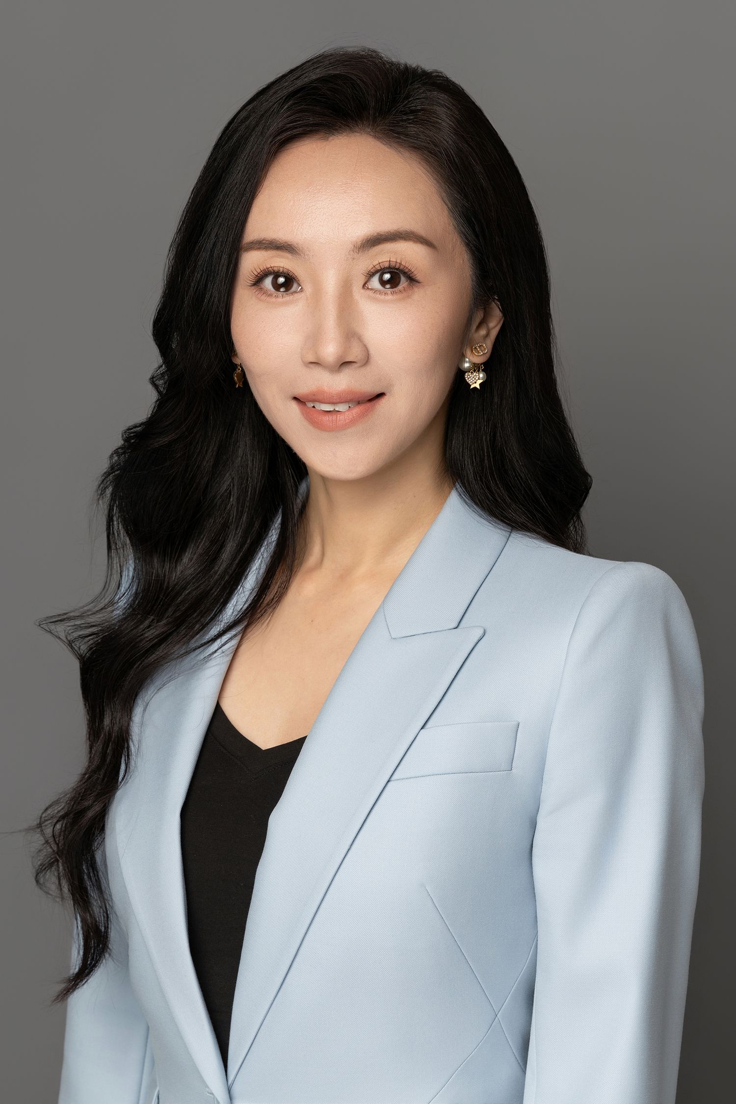 Professional headshots of woman in light blue blazer against dark background.