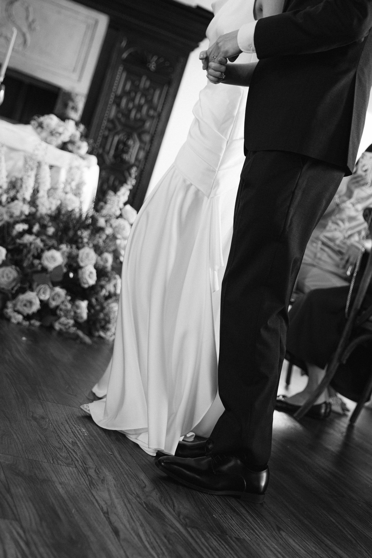 Black and white capture of wedding dance moves on hardwood floor.