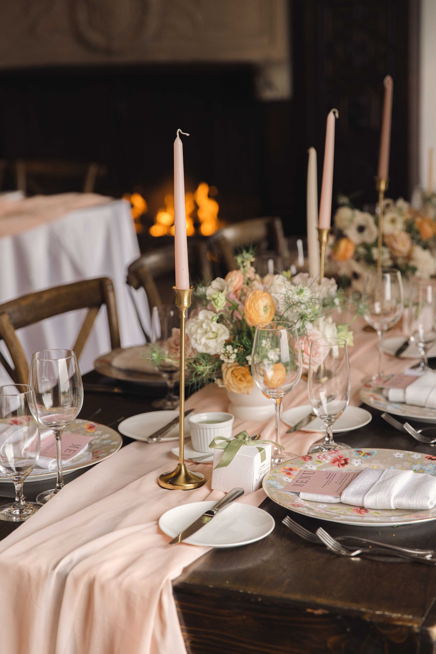 Elegant wedding reception table setting with candles, white linens, and romantic decor.