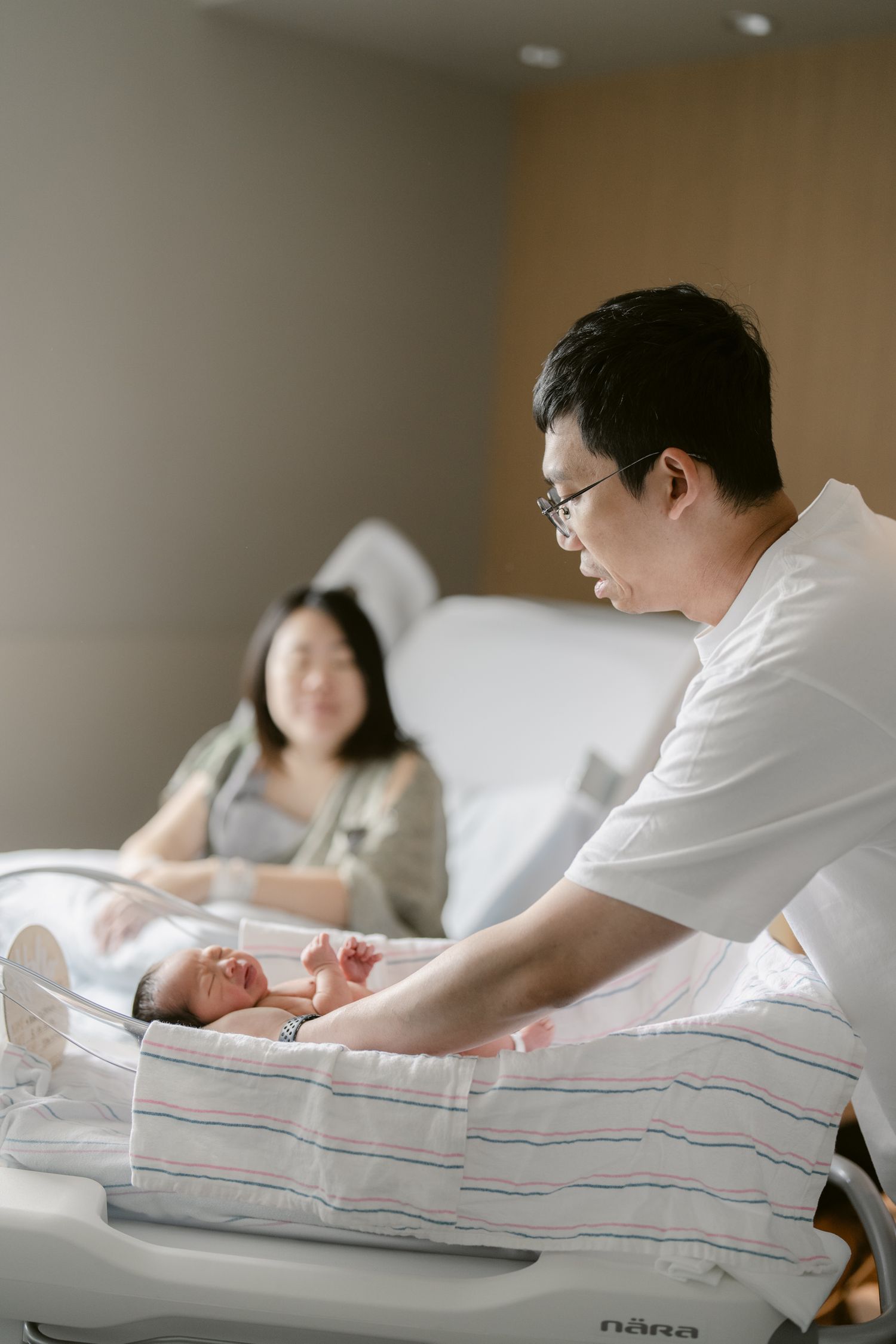 Healthcare provider examines a newborn baby in a hospital setting.