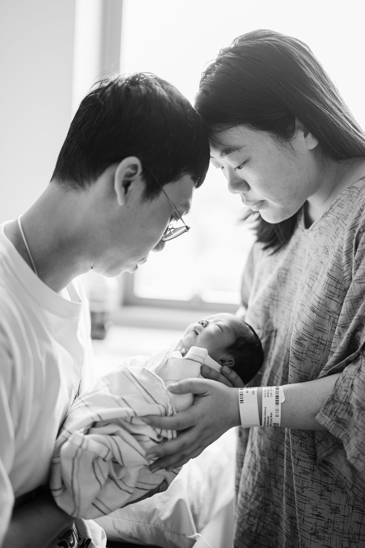 A tender series of black and white photographs showing a newborn baby being cradled.