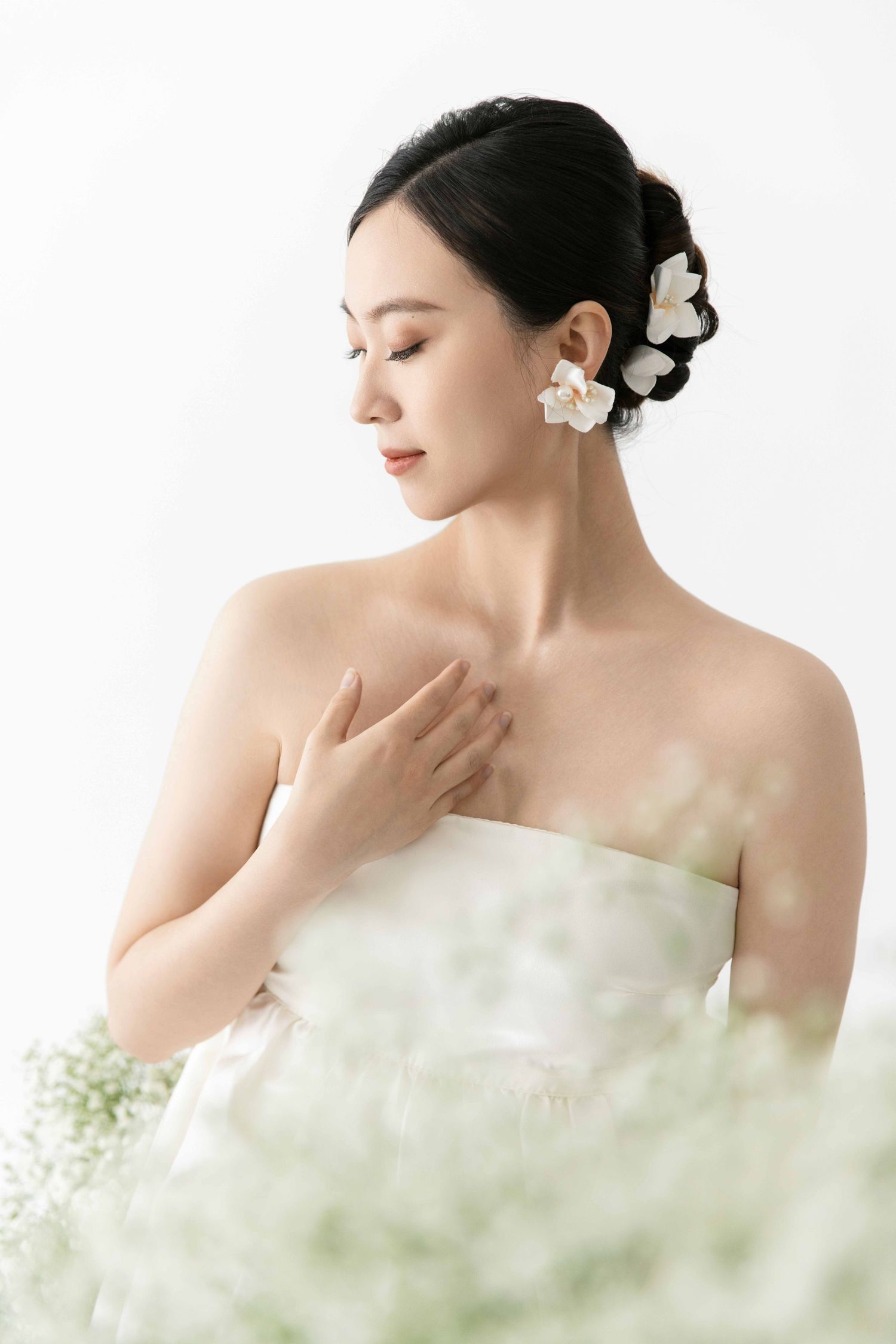 Dreamy maternity portrait with baby's breath flowers creating ethereal atmosphere.