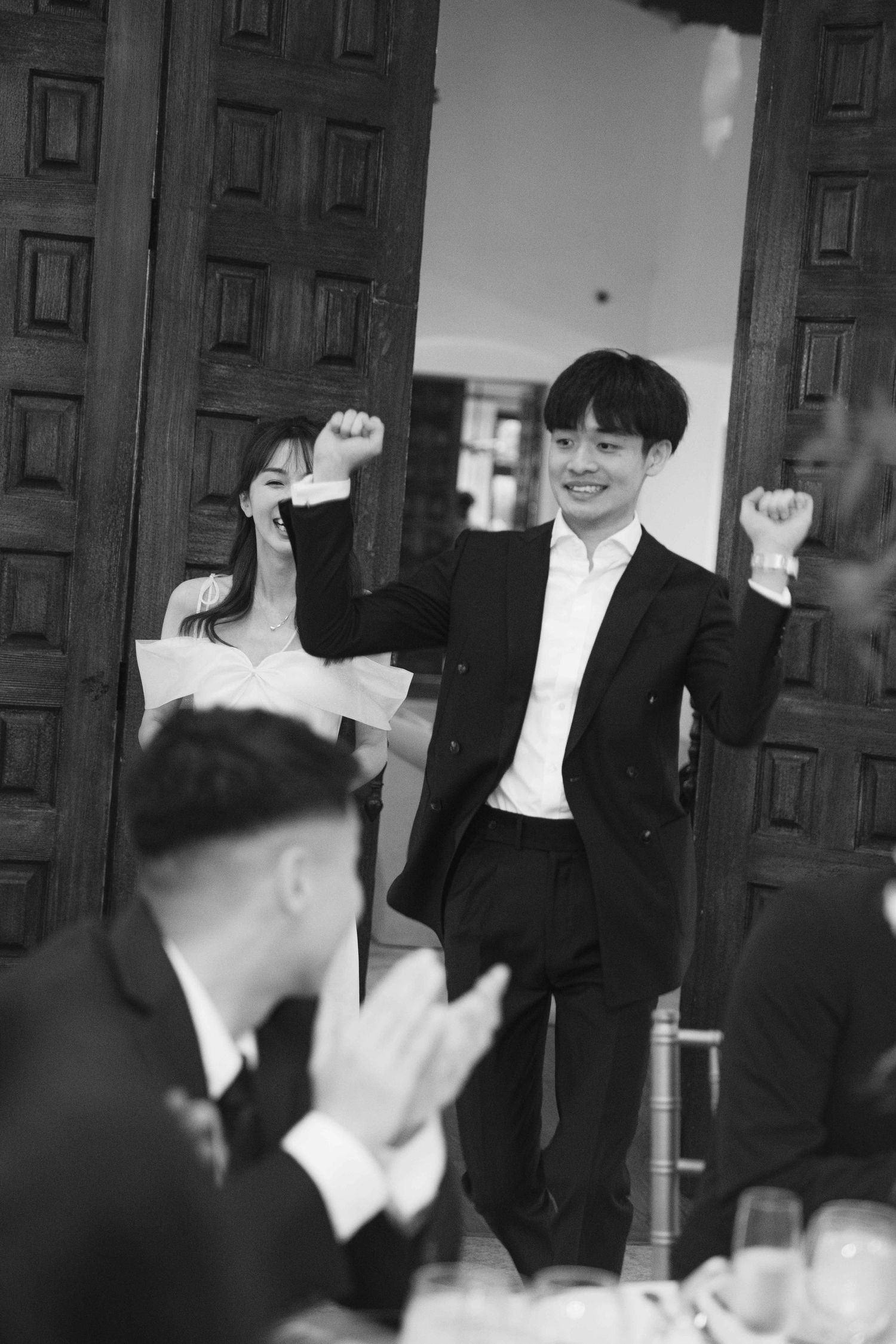 Black and white candid reception photos showing guests laughing and celebrating.