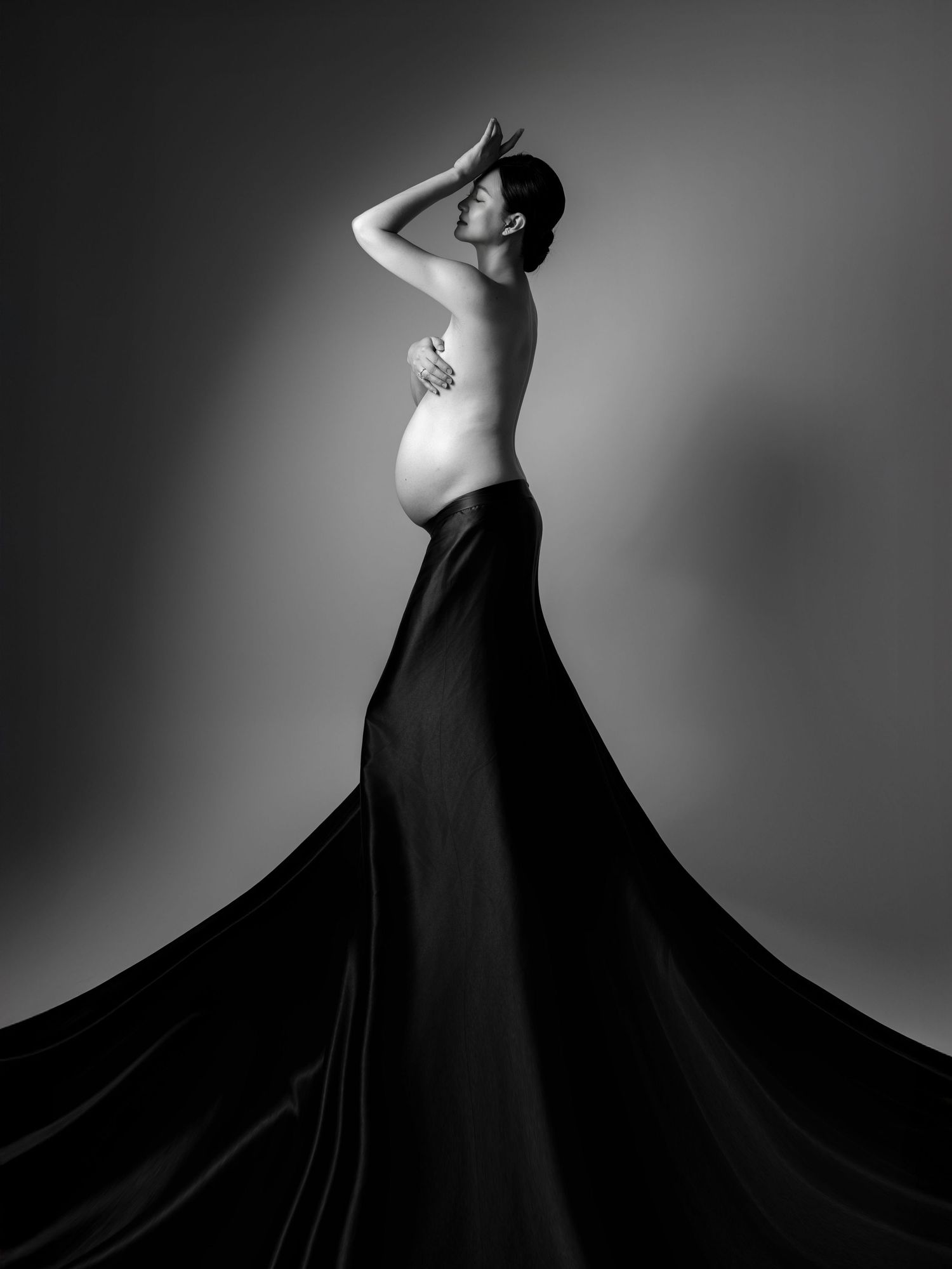Artistic black and white maternity silhouette with flowing dress.