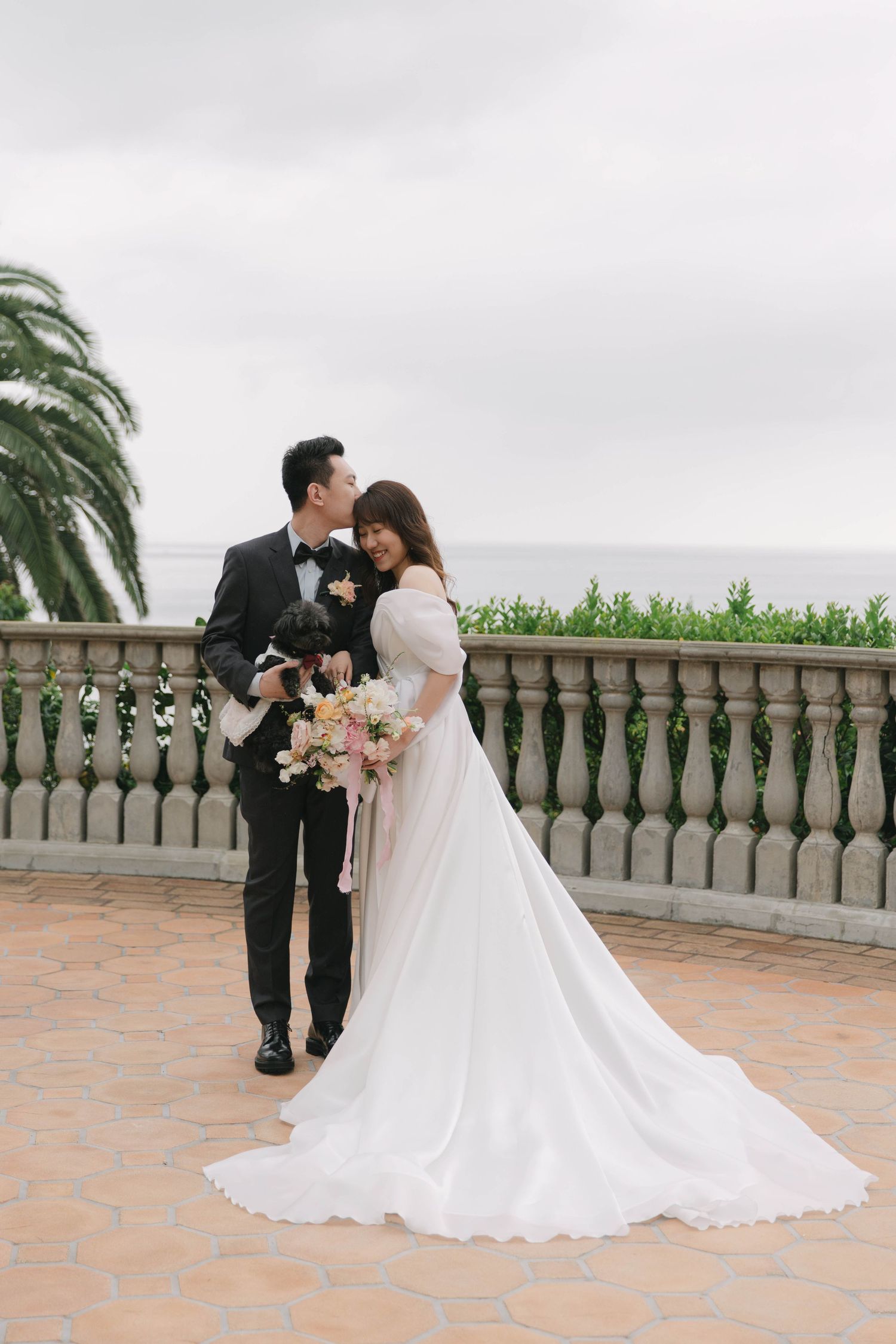 Romantic wedding portraits on a stone terrace overlooking a scenic landscape.