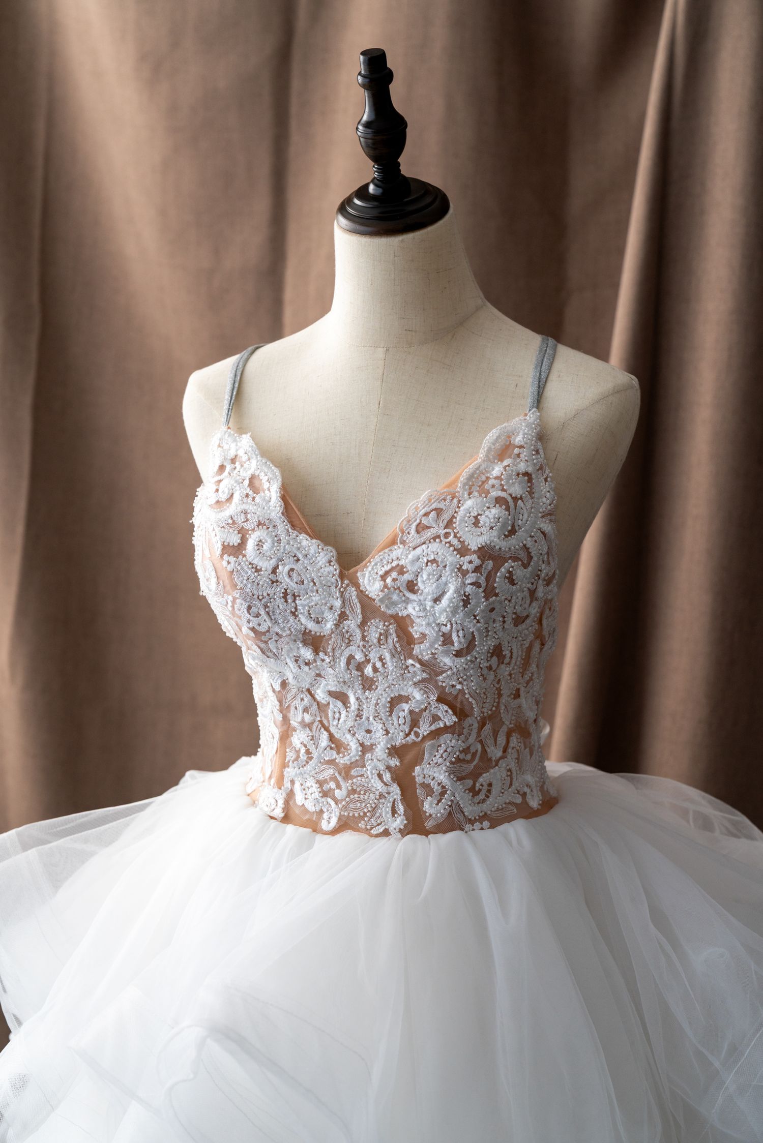 Wedding gown featuring intricate lace bodice with nude underlay and full tulle skirt.