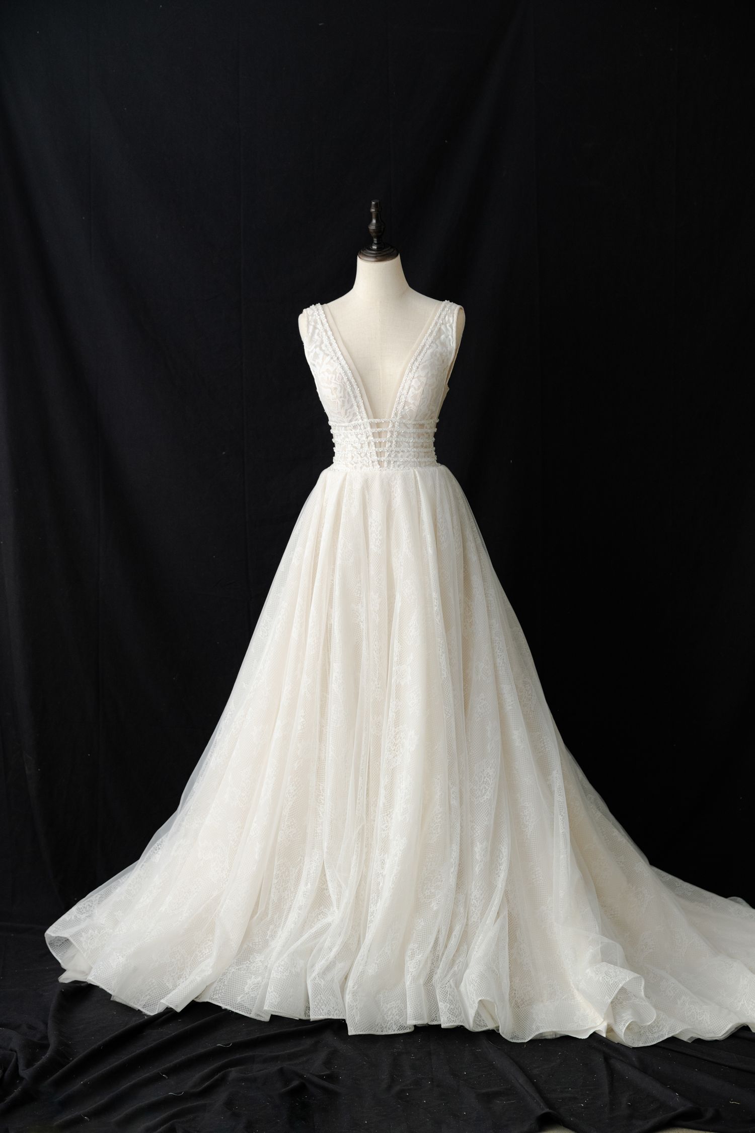 Back view of empire waist wedding dress with plunging V-back and tulle train.