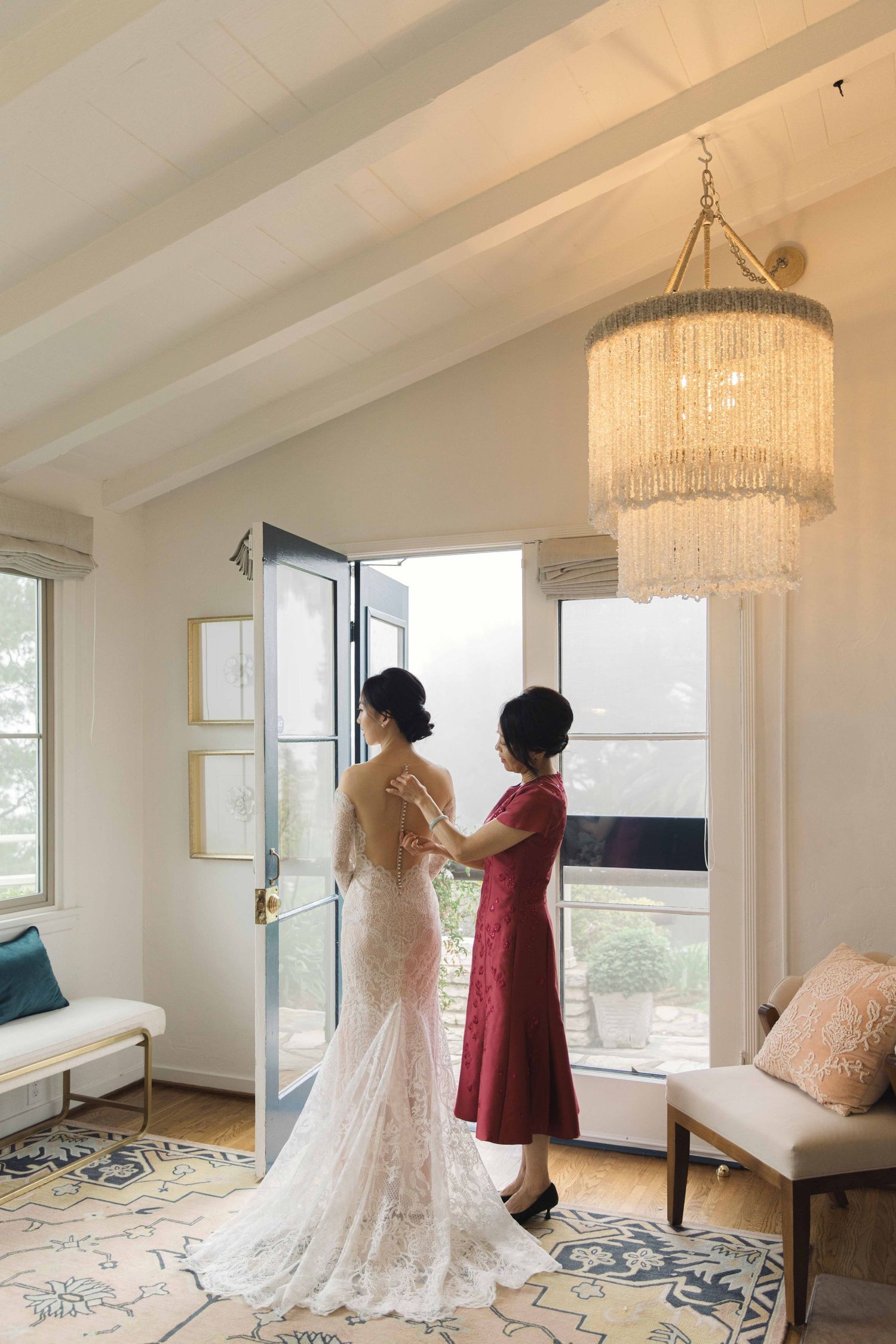 Bright modern room with chandeliers showing wedding dress preparation.