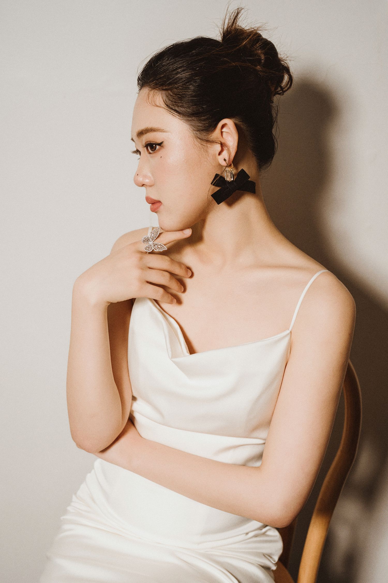 Artistic portrait series showing graceful poses in white satin dress against minimalist background.