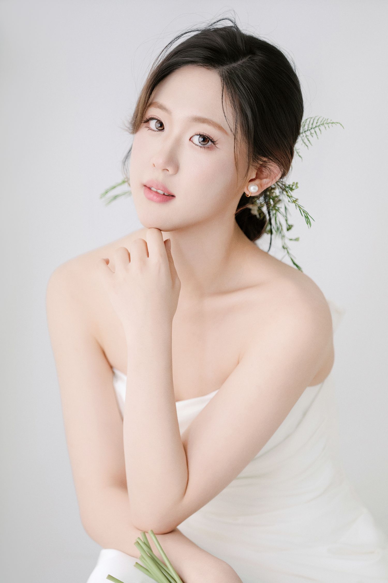 Dreamy bridal photoshoot featuring minimalist white dress and natural greenery styling.