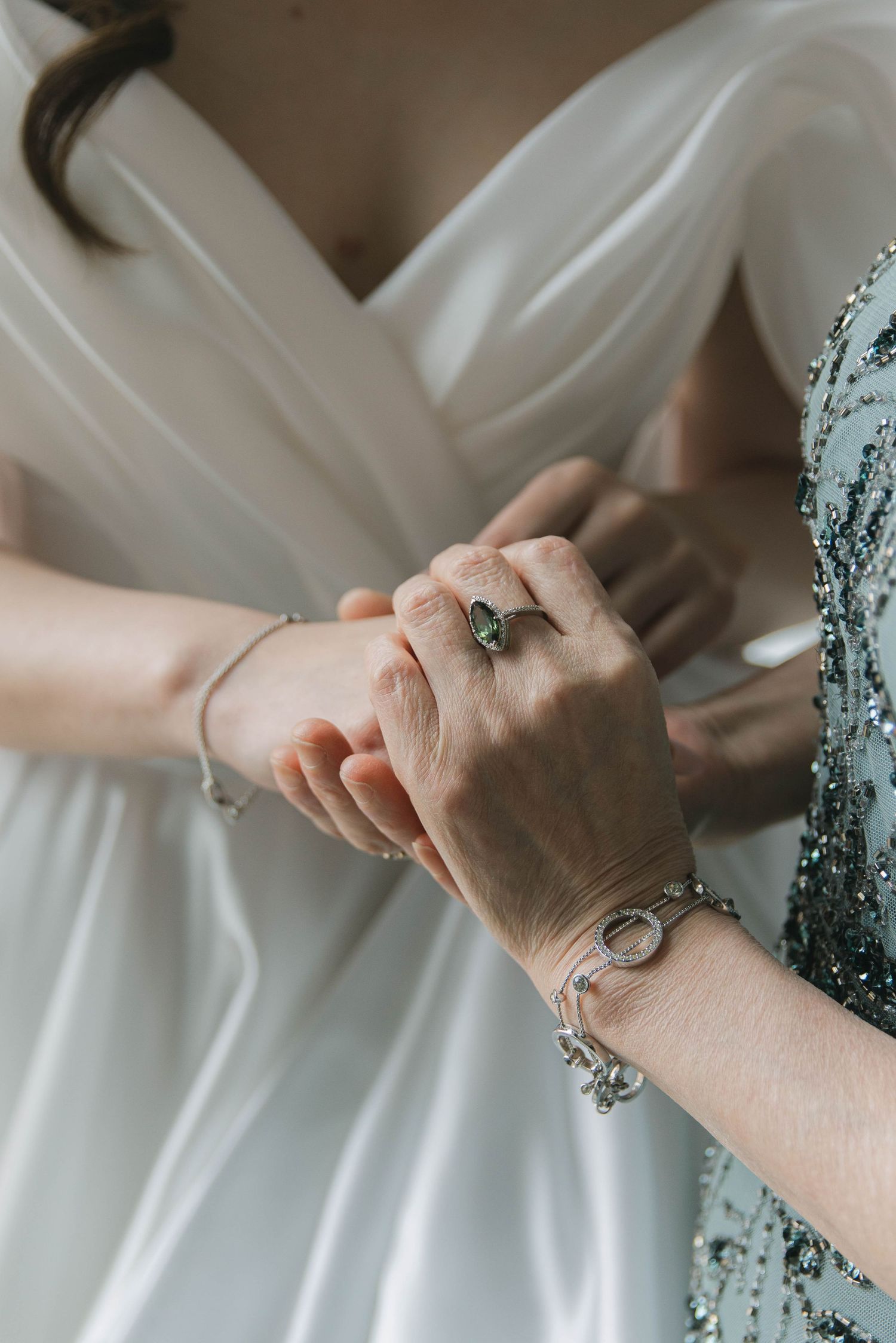 Close-up shots of hands adjusting and smoothing out details on a white wedding dress.