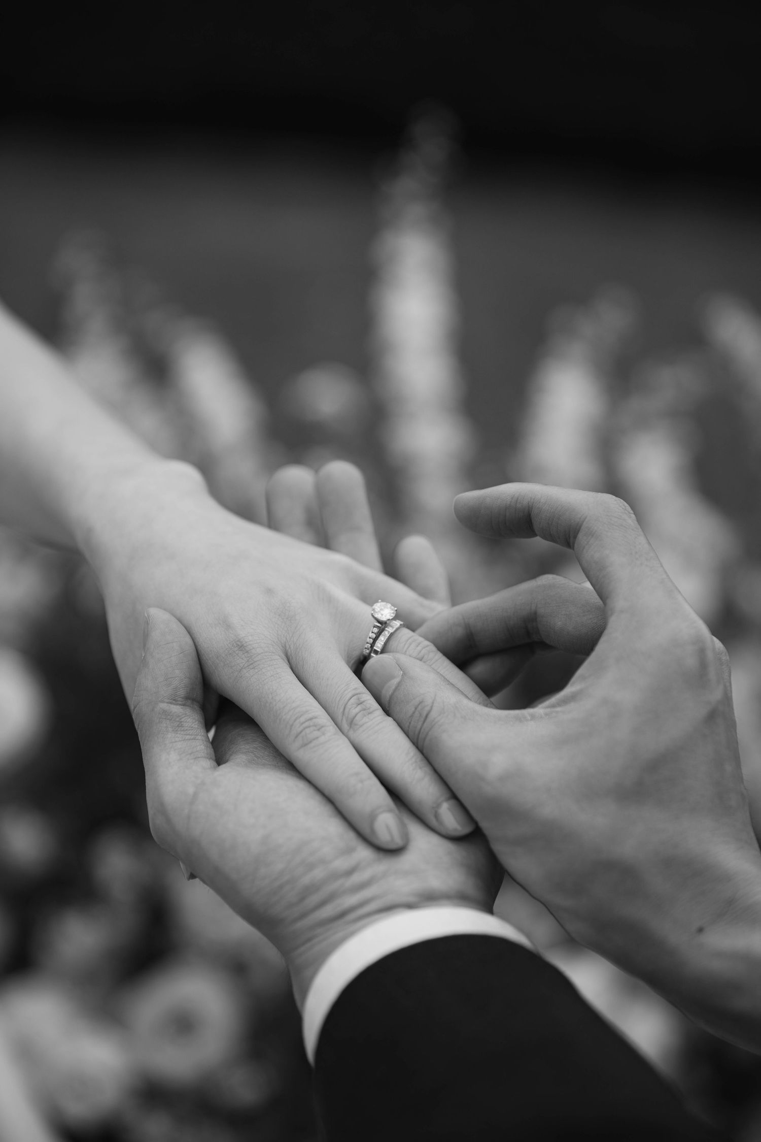 Close-up of hands exchanging wedding rings during the ceremony.