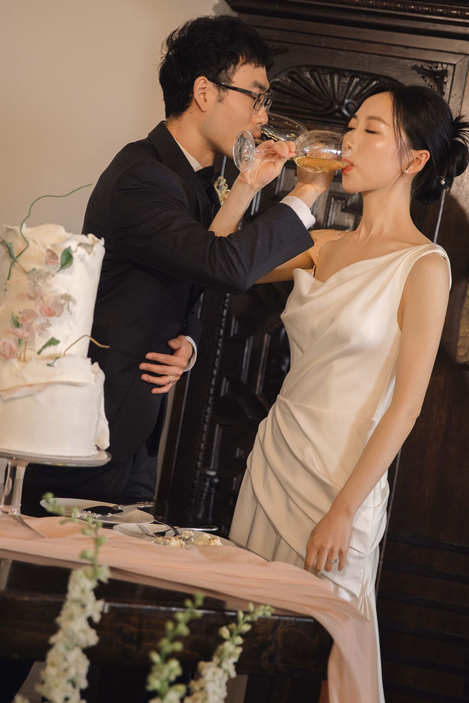 Newlyweds share champagne during their wedding cake cutting ceremony.