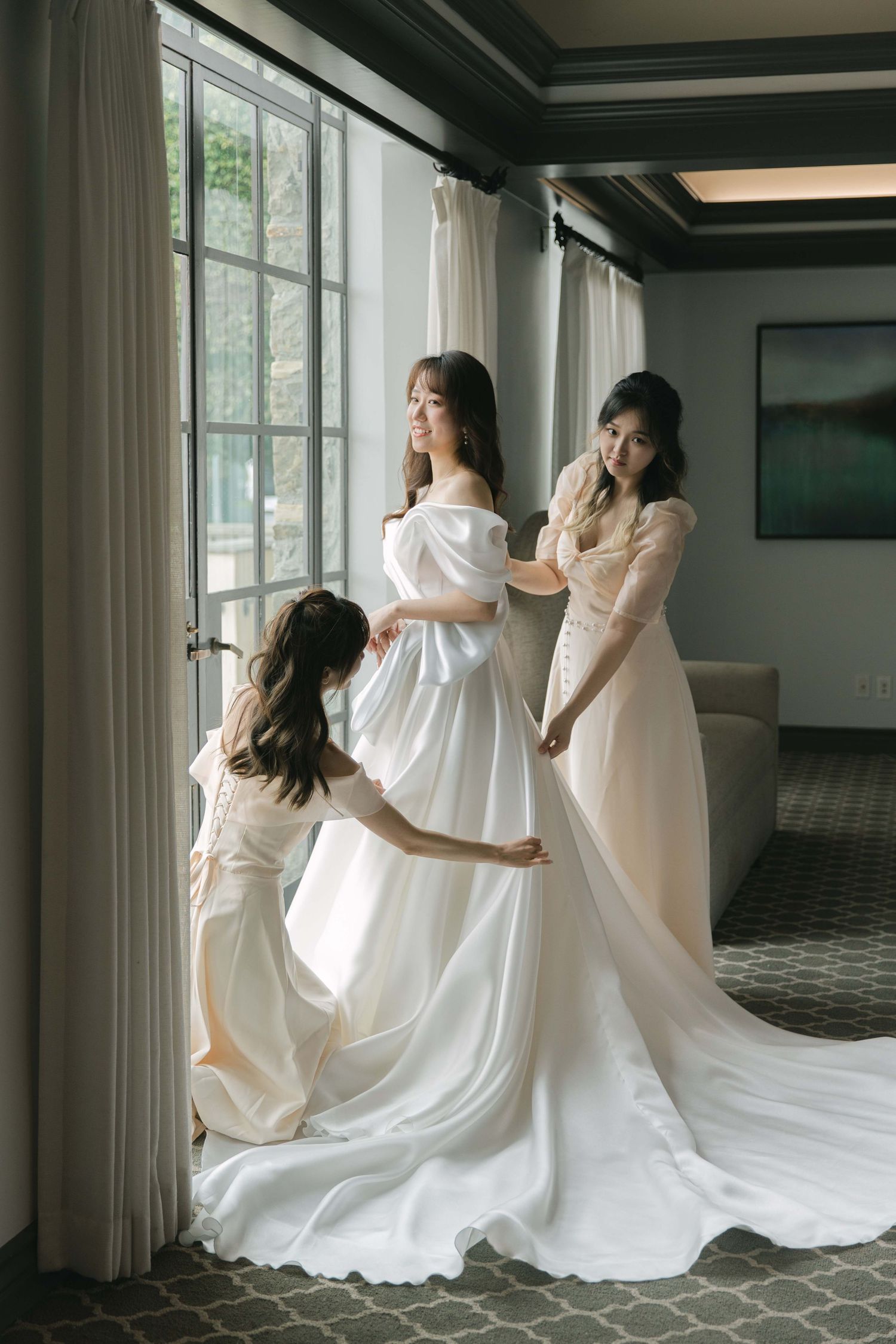 Multiple shots of people in white dresses dancing and twirling in an elegant room with large windows.