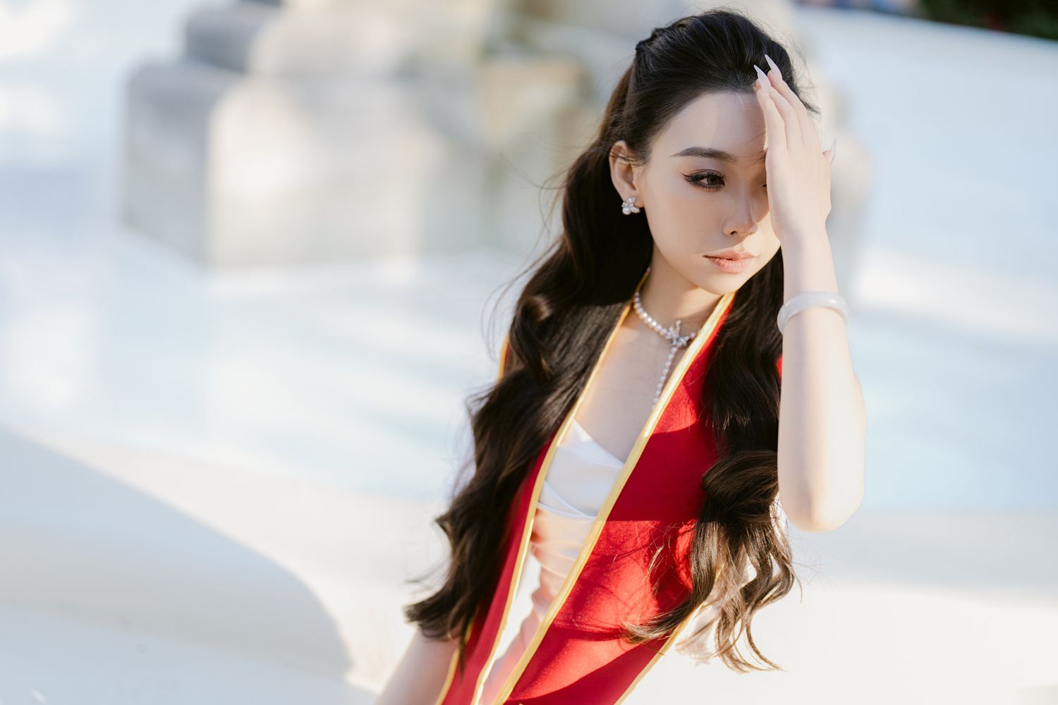 Graduation portrait session outdoors with red academic stole.
