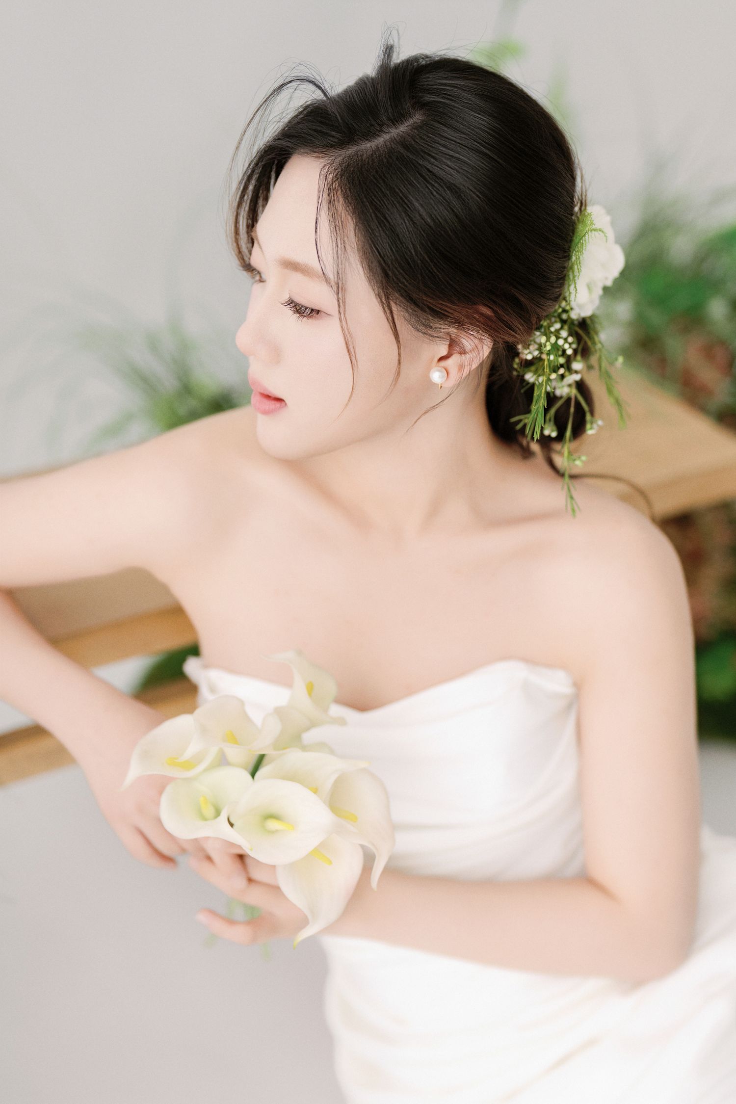 Elegant white dress portraits with calla lilies against minimalist background.