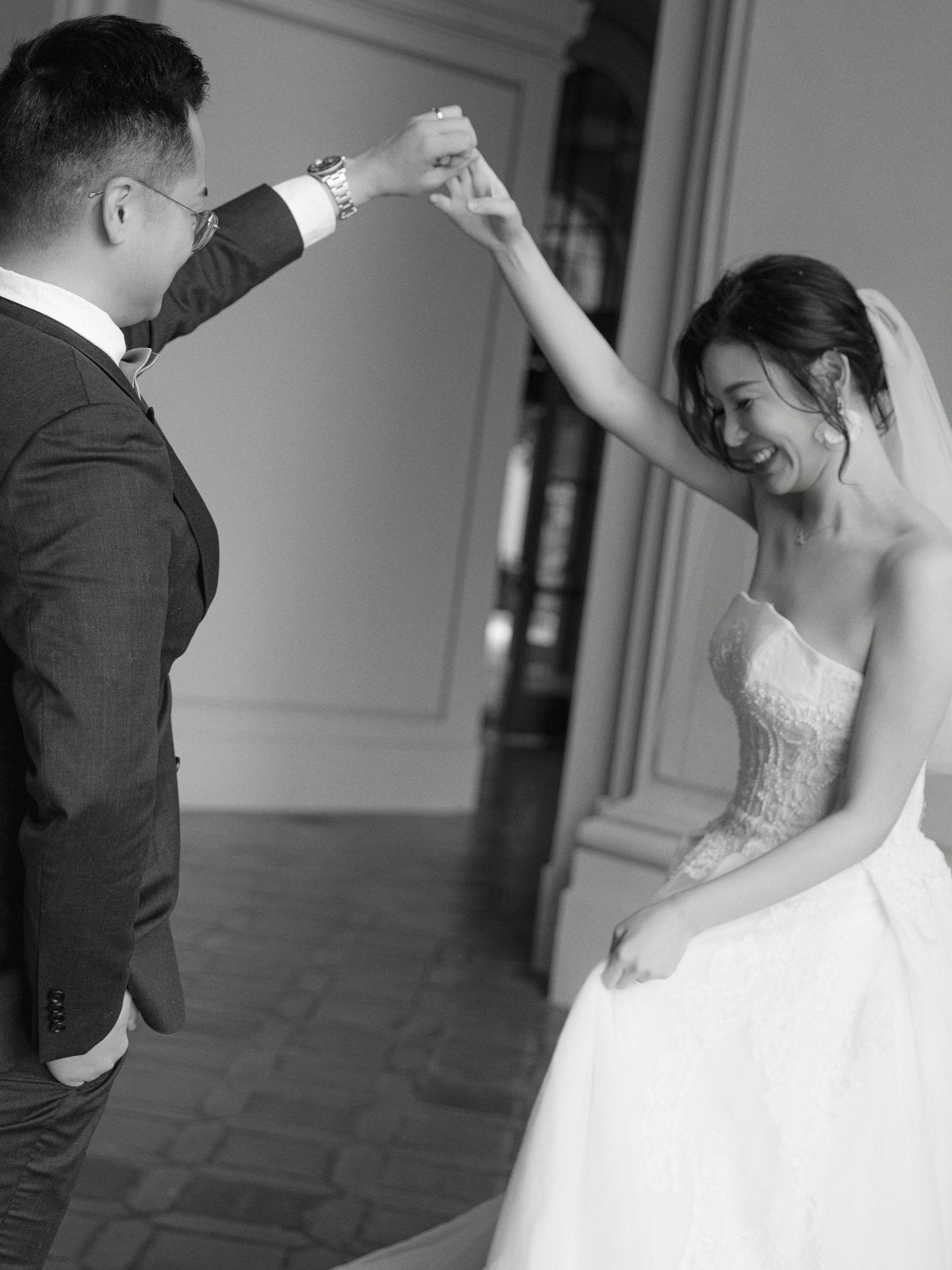 Couple dancing in formal wedding attire in black and white.