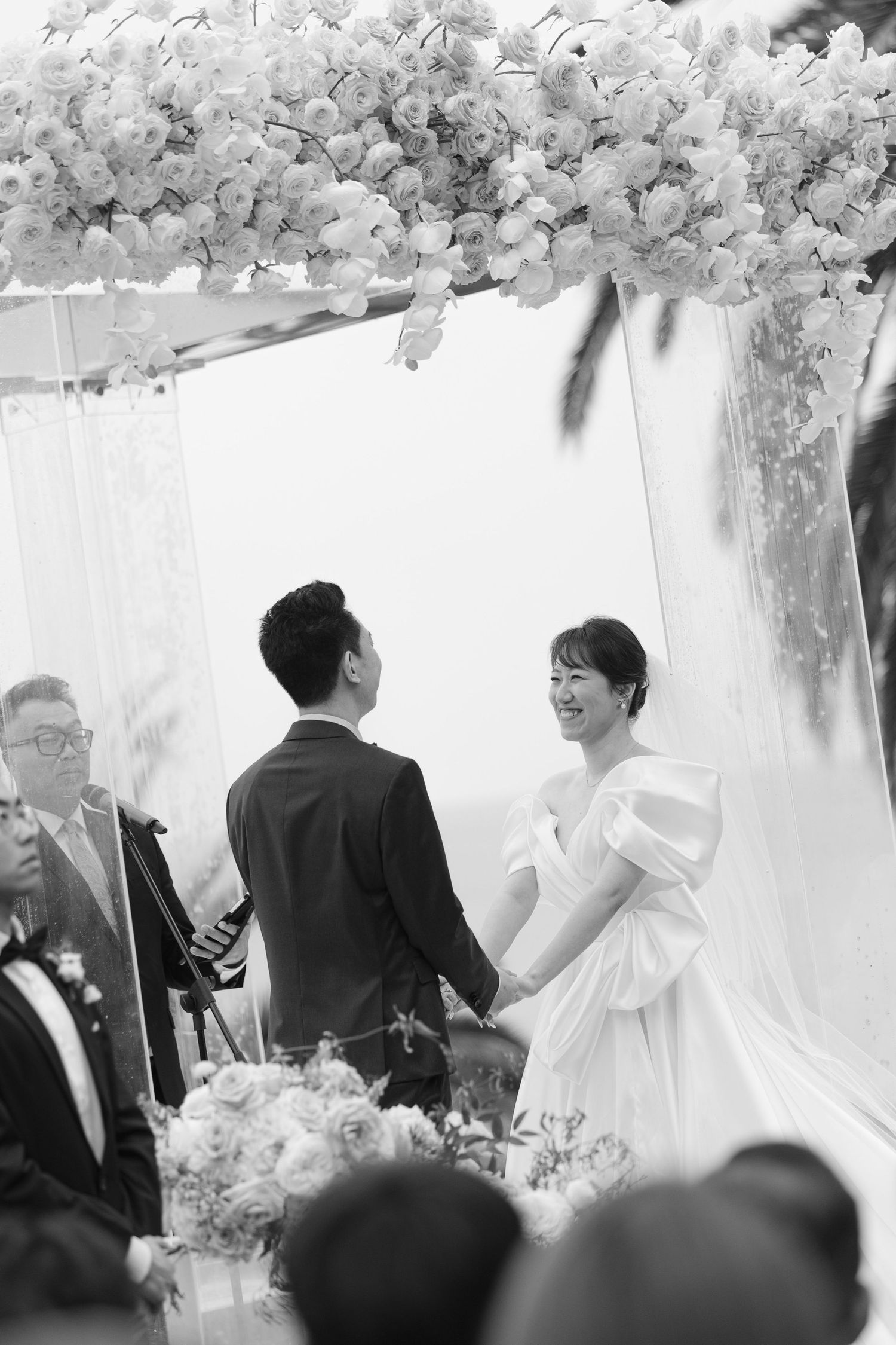 Wedding reception celebration under white floral arrangements with joyful moments.