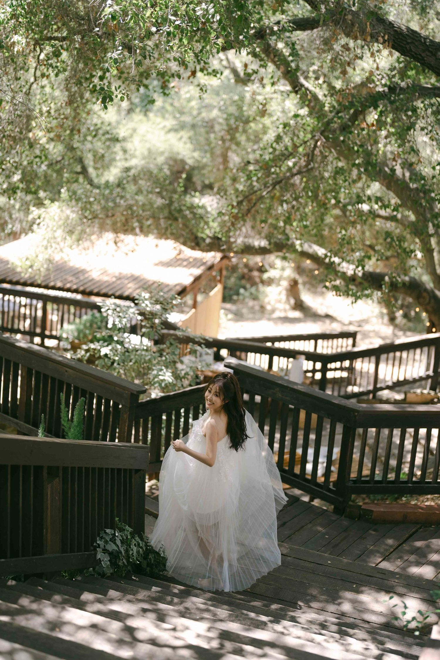 Sunlit wooden deck with white wedding dress details visible in natural lighting.