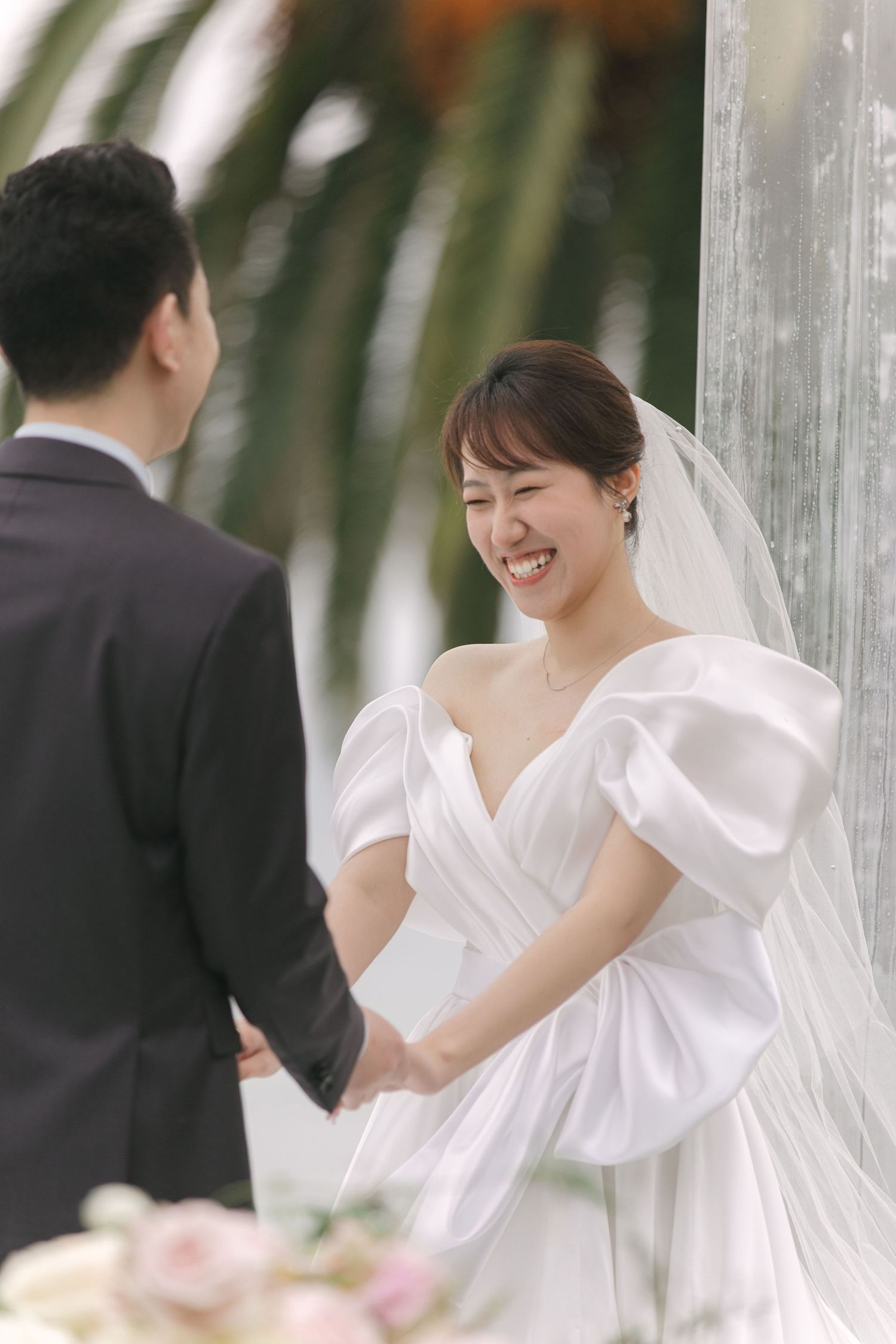 Candid wedding moments captured under white pillars with flowing veils.