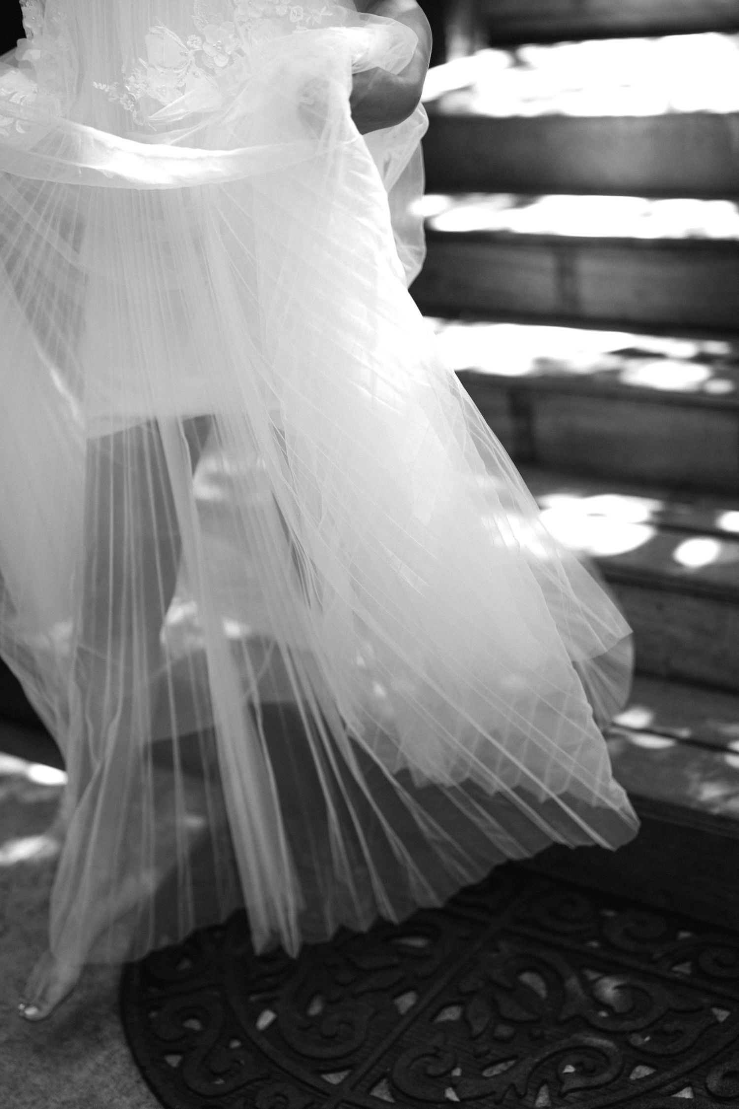 Close-up details of flowing white tulle wedding dress fabric in black and white.