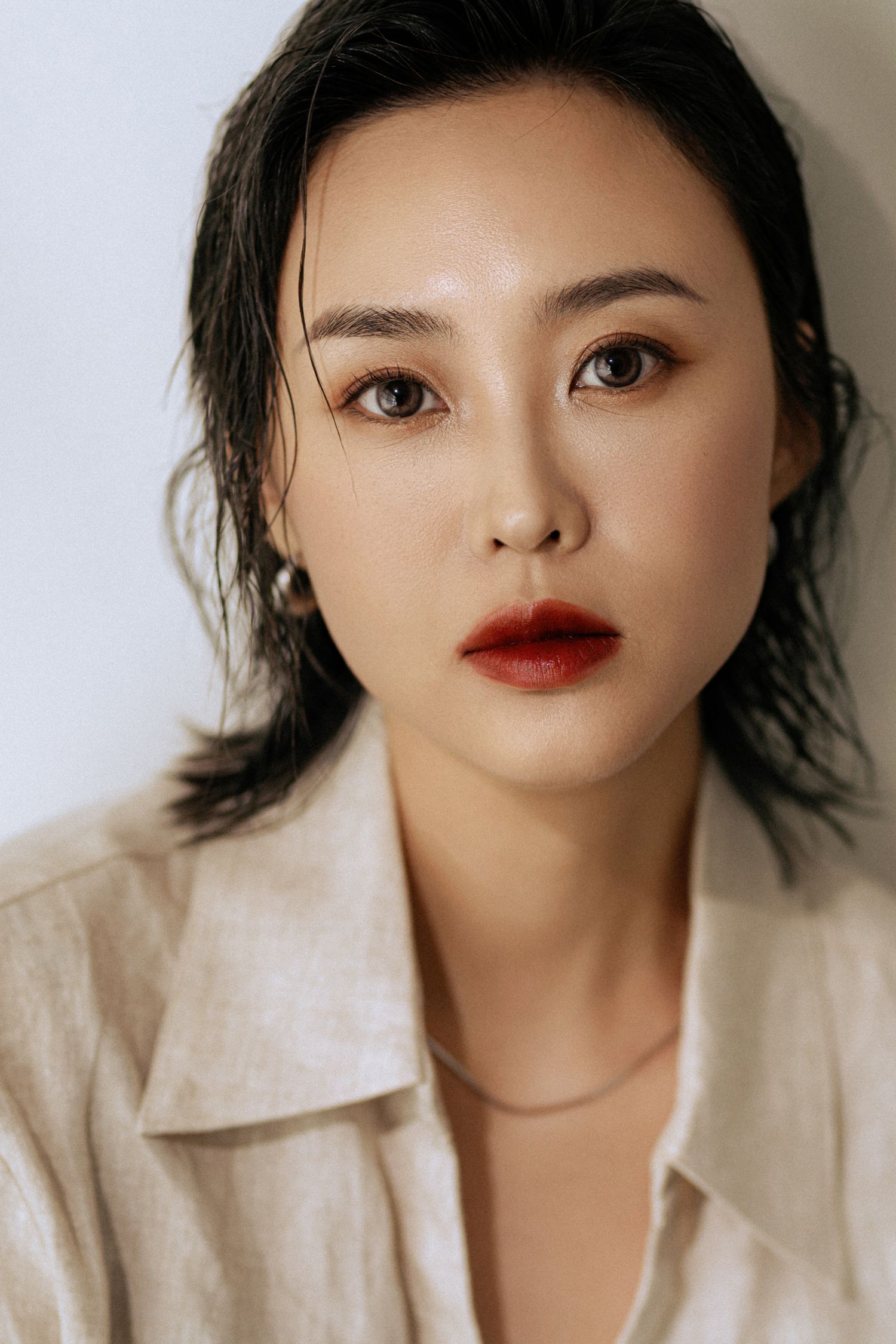 Contemporary beauty shot with sophisticated makeup and delicate necklace detail.
