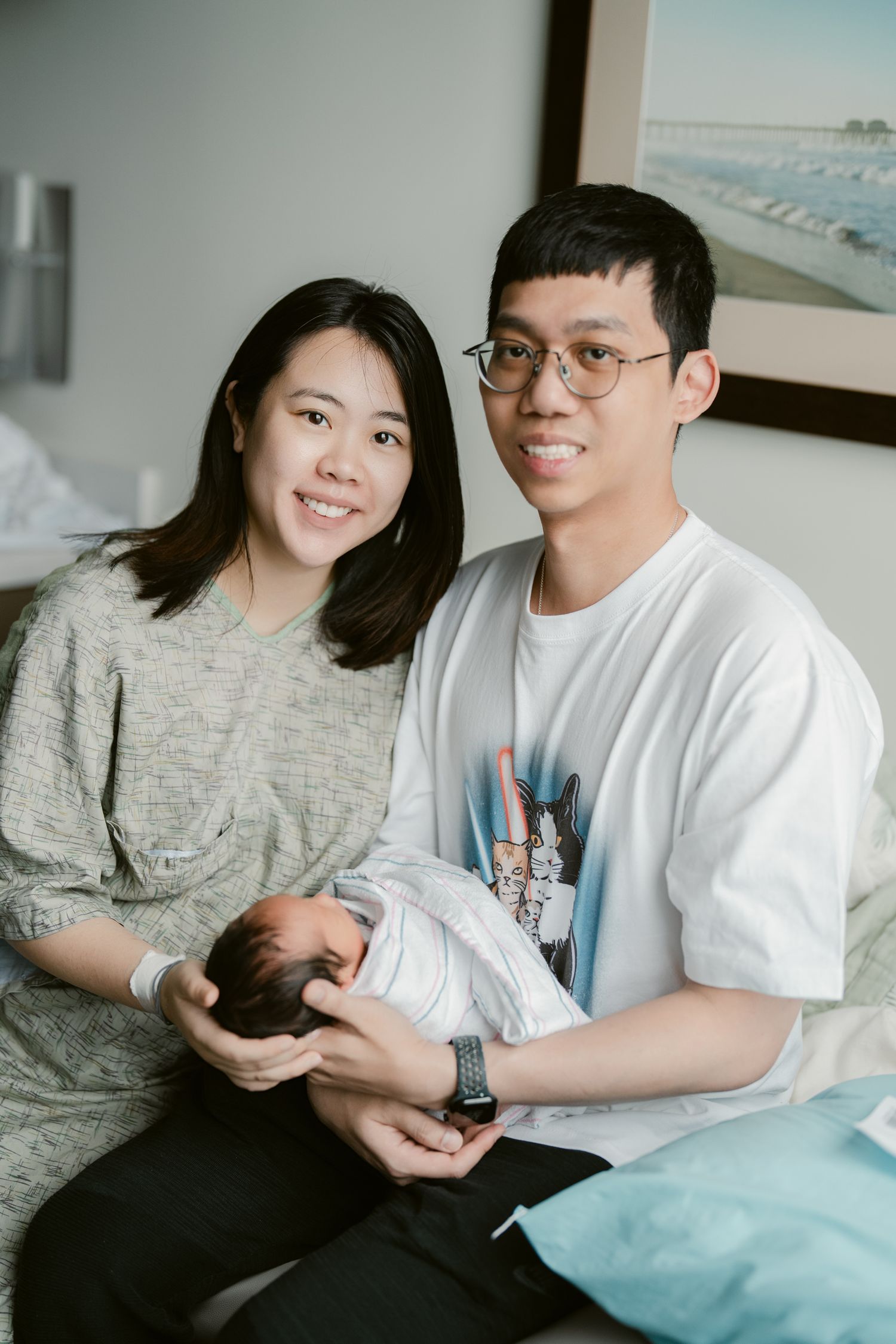Parents bonding with their newborn baby in a bright hospital room.