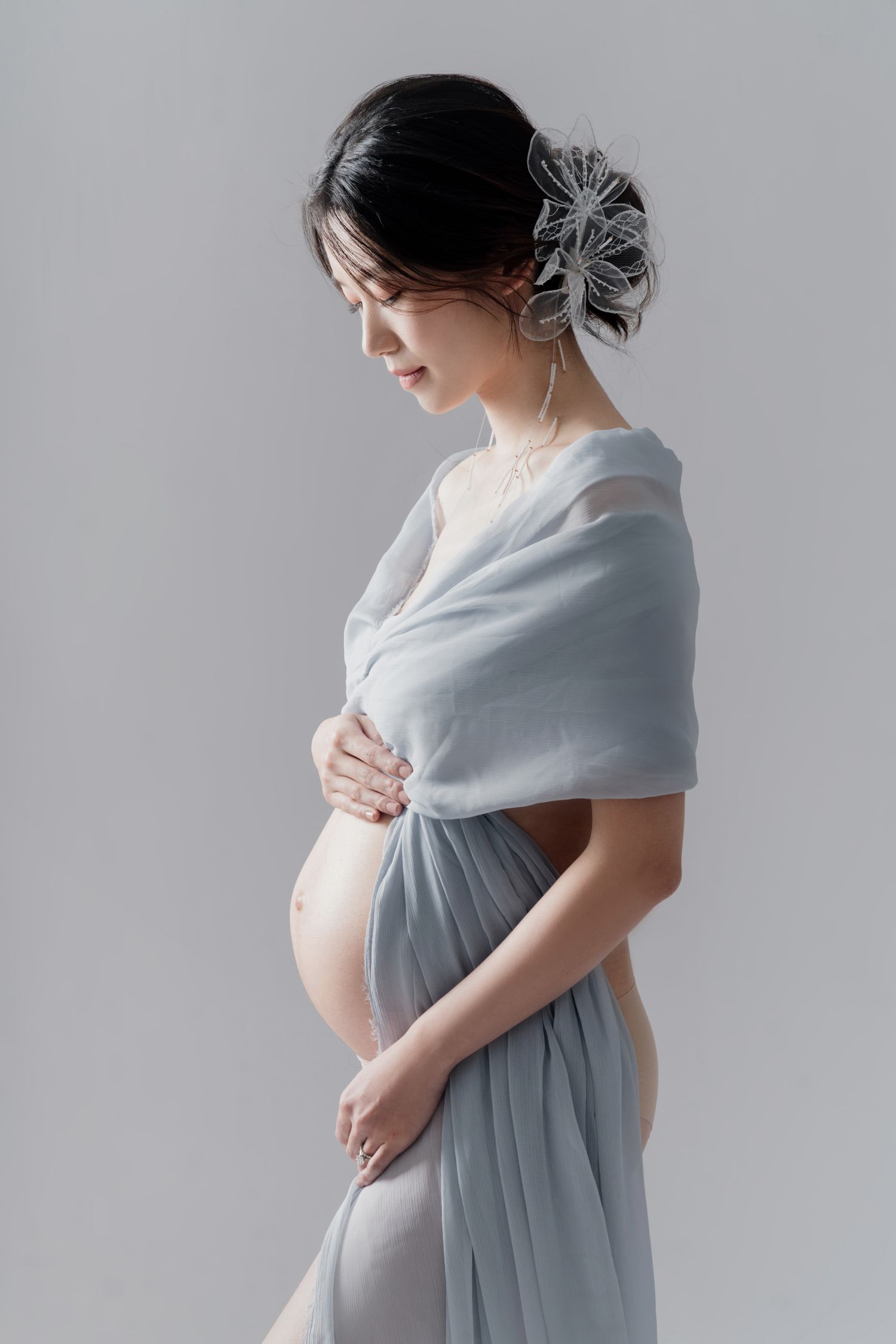 Elegant maternity photos with woman in soft grey dress and wrap.