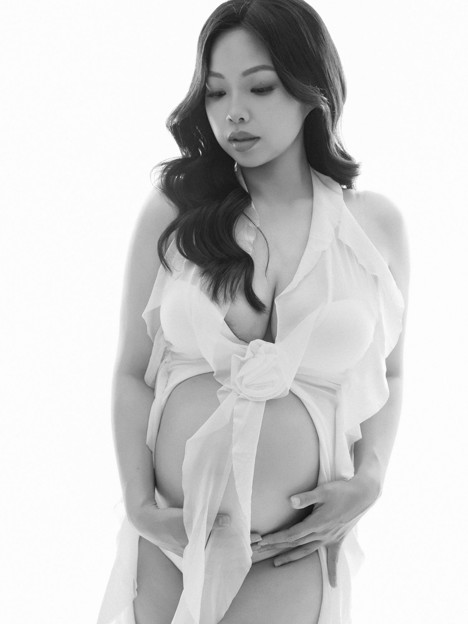 A figure in a white sheer blouse poses elegantly in a series of artistic black and white photographs.
