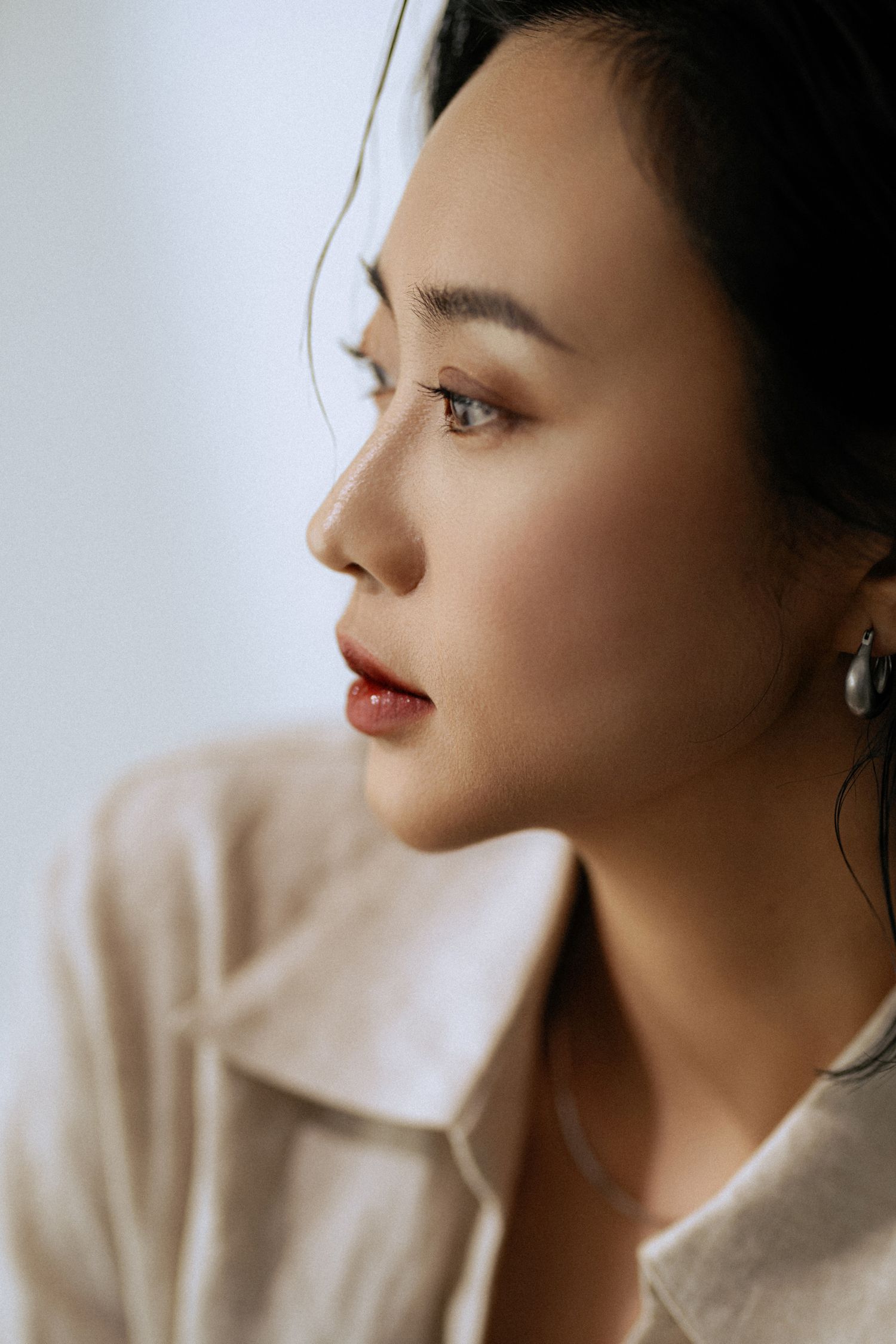 Side profile beauty shot with focus on classic red lip and natural makeup.