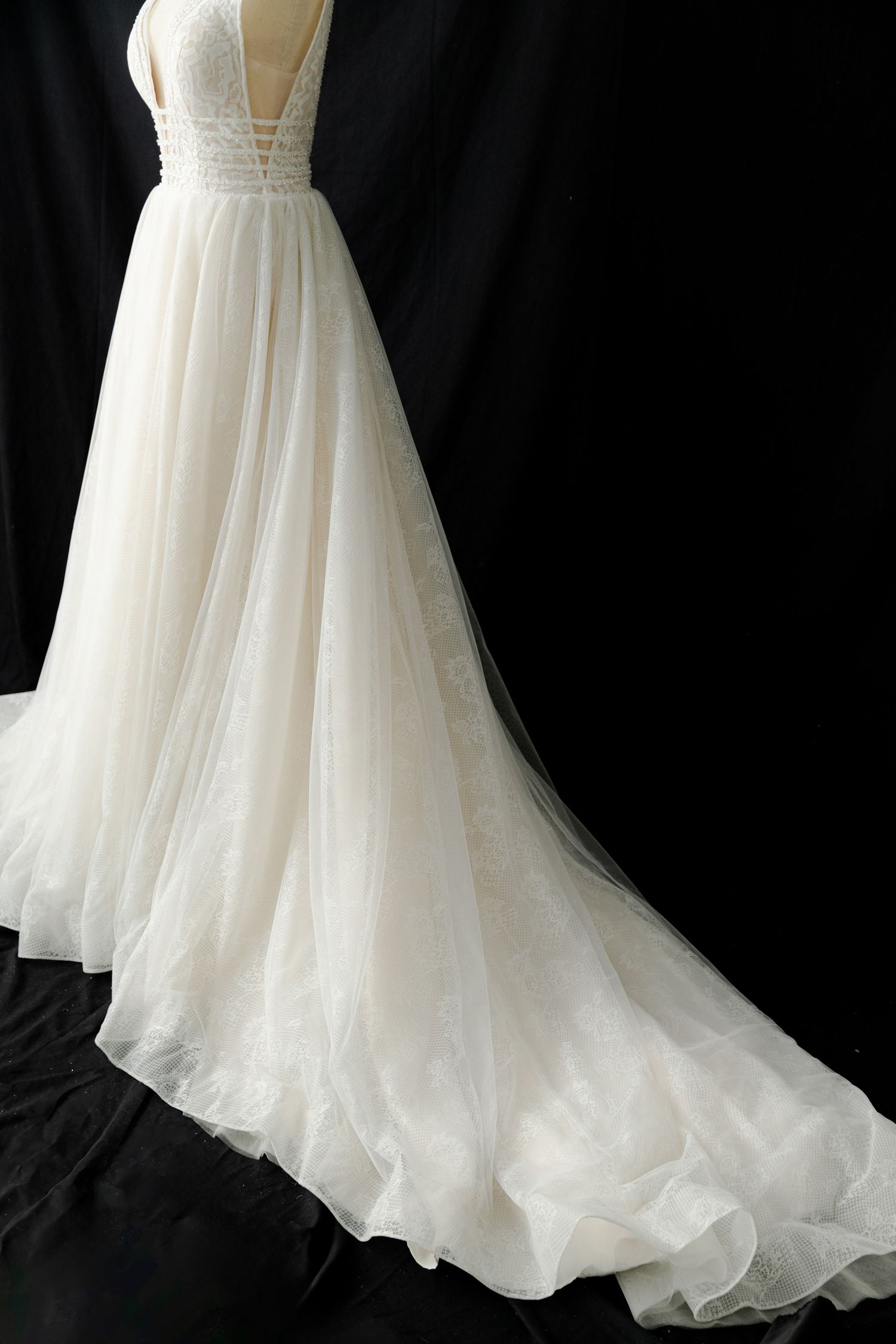 Full-length view of ethereal white wedding gown with flowing tulle skirt.