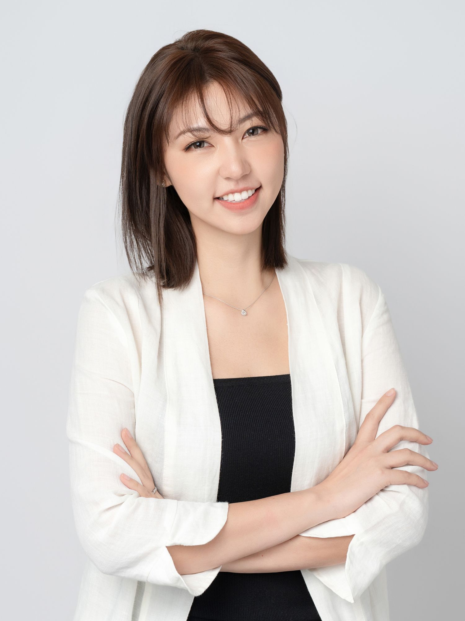 Business portrait series showing confident poses in white blazer against neutral backdrop.