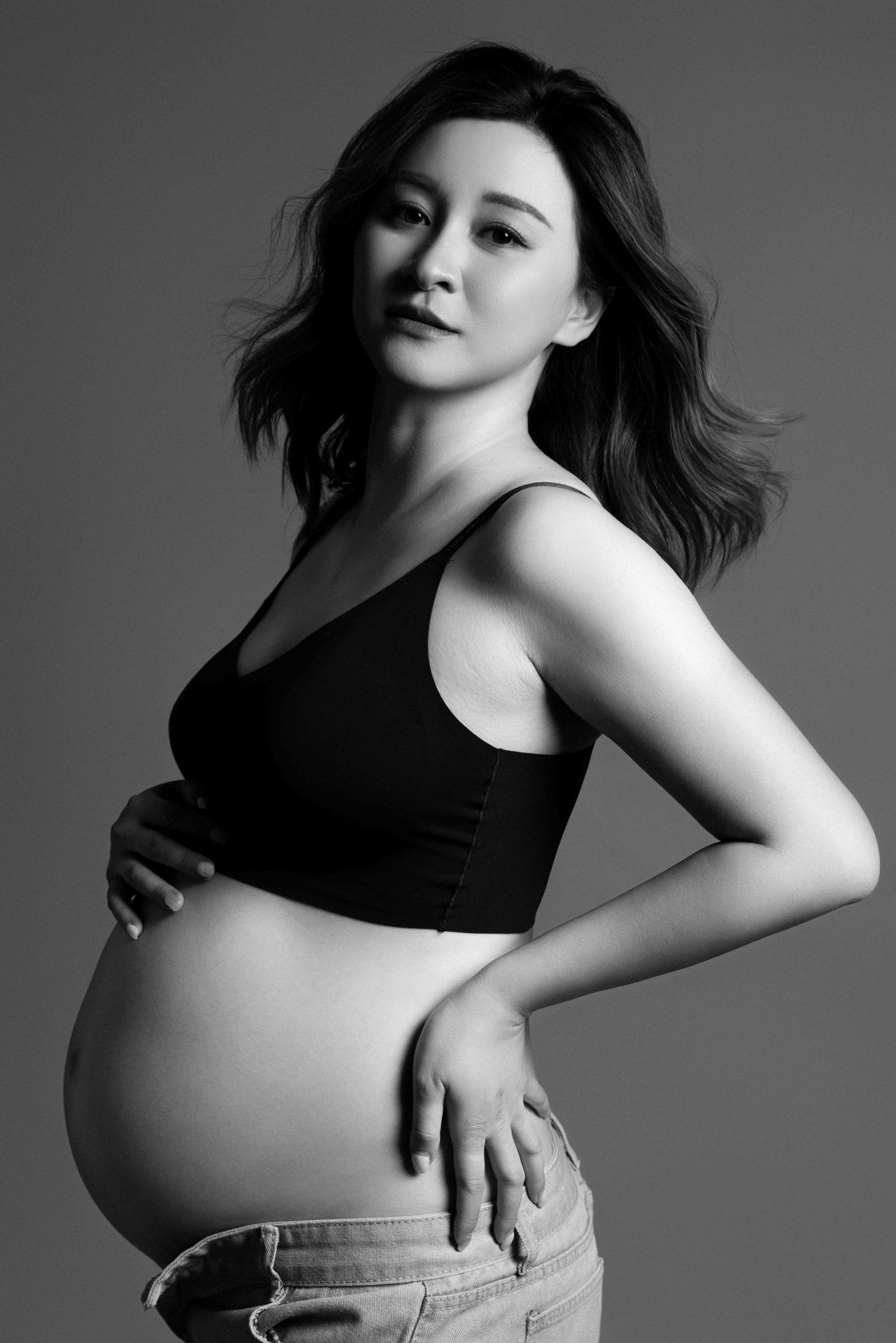 Black and white maternity photos showing contrast and movement in studio setting.