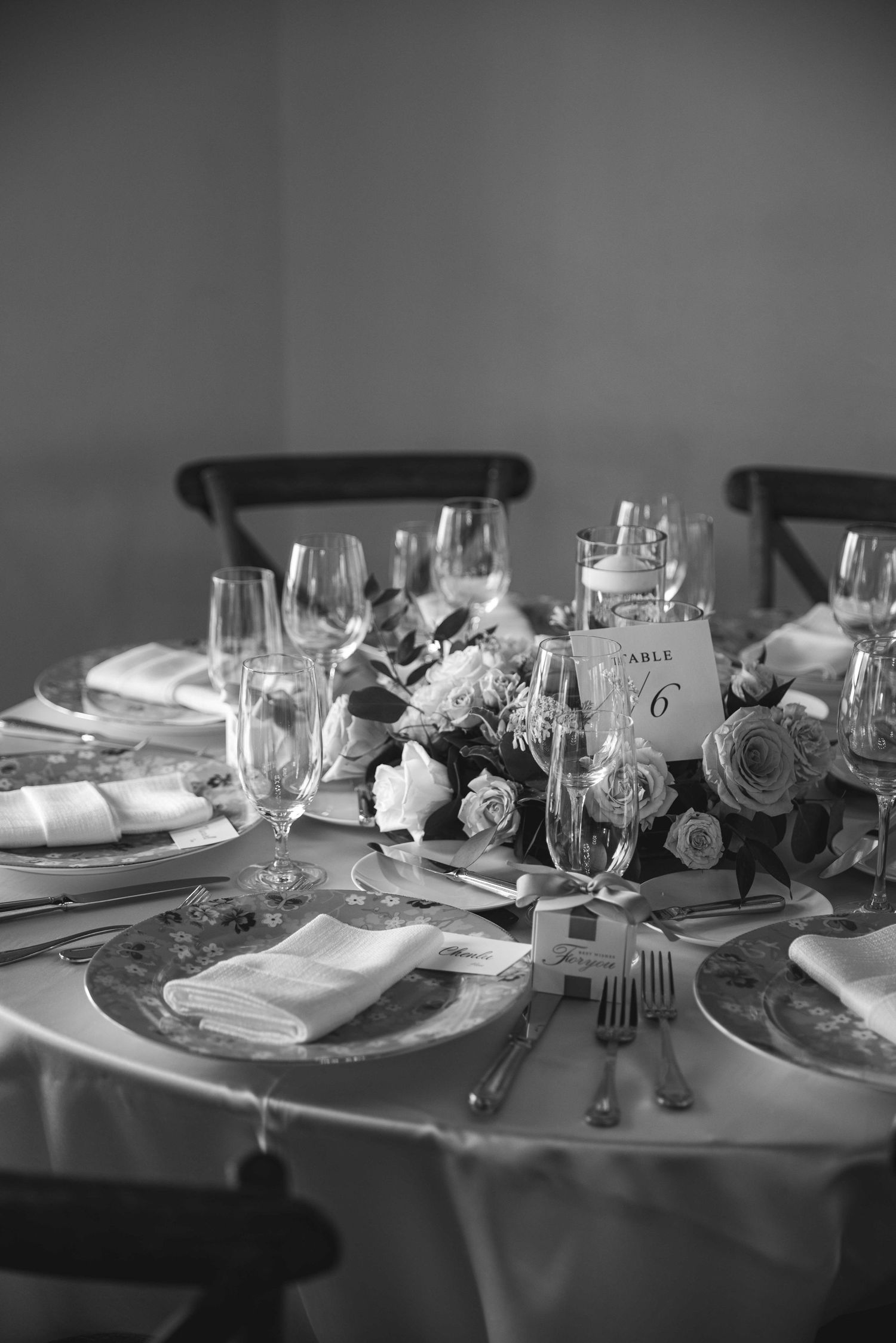 Black and white photo of an elegant wedding table setting with formal place settings and centerpieces.