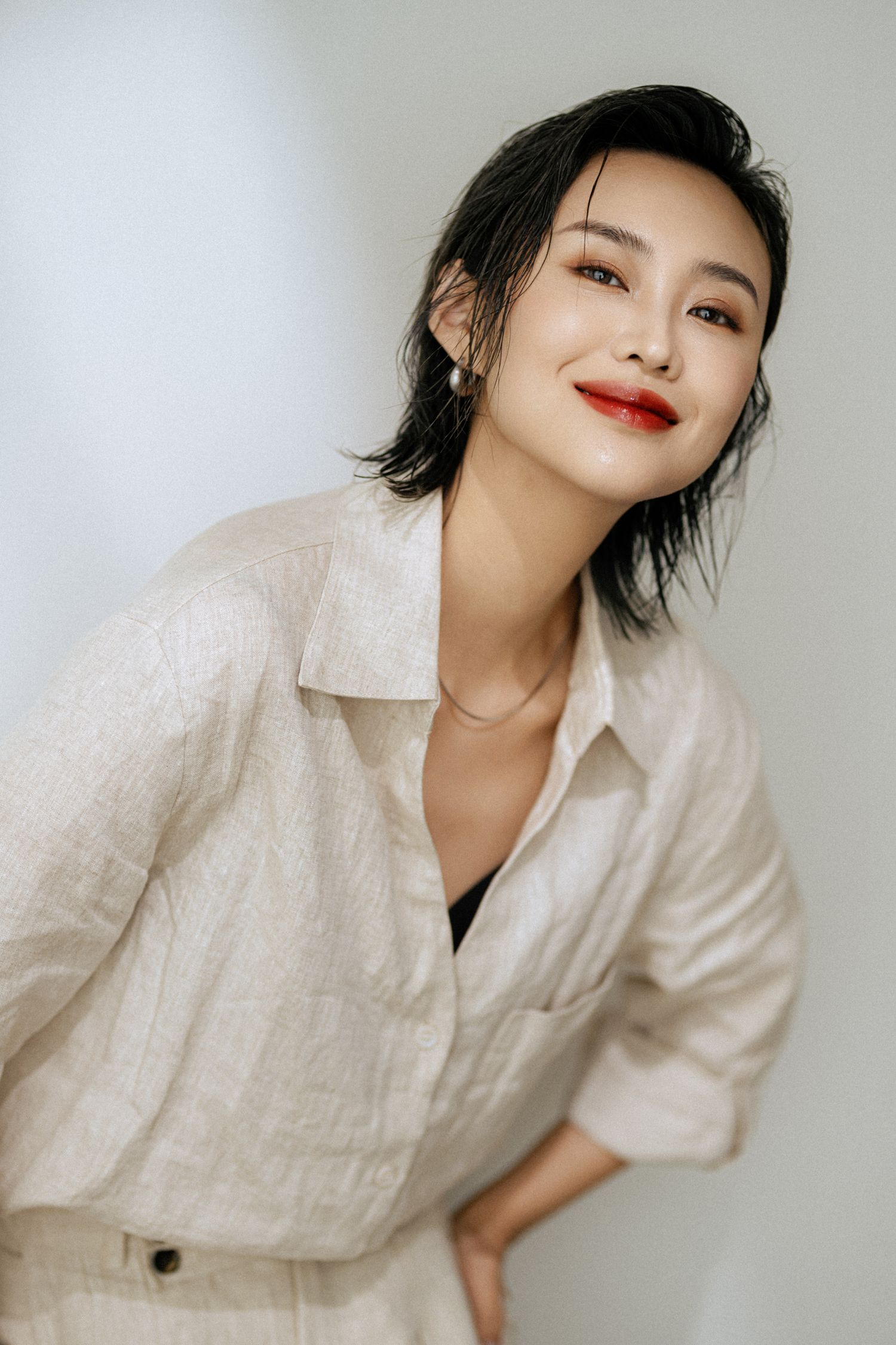 Editorial style portrait in white linen shirt with natural makeup and styling.
