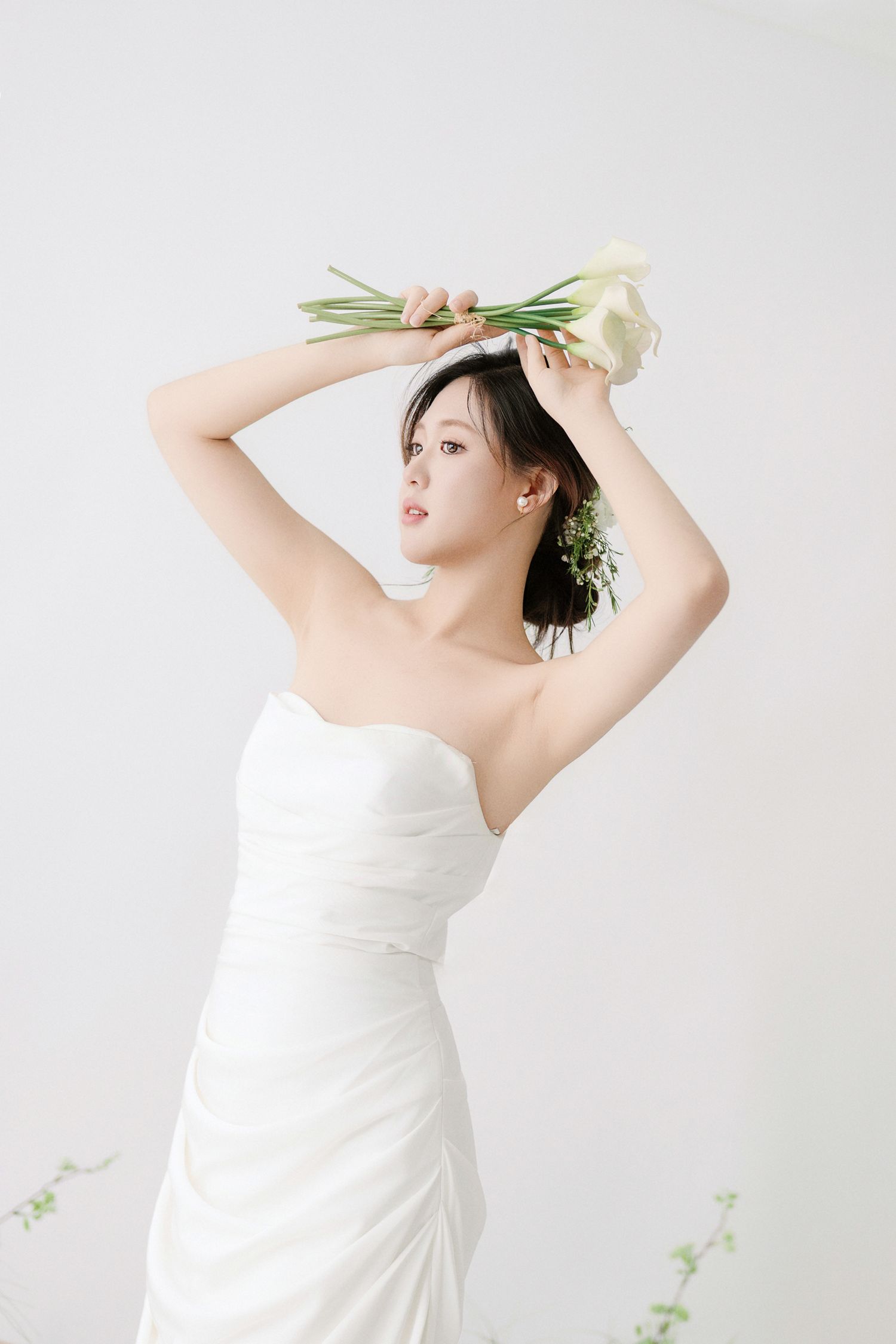 Artistic bridal photos with dramatic poses and white floral elements.