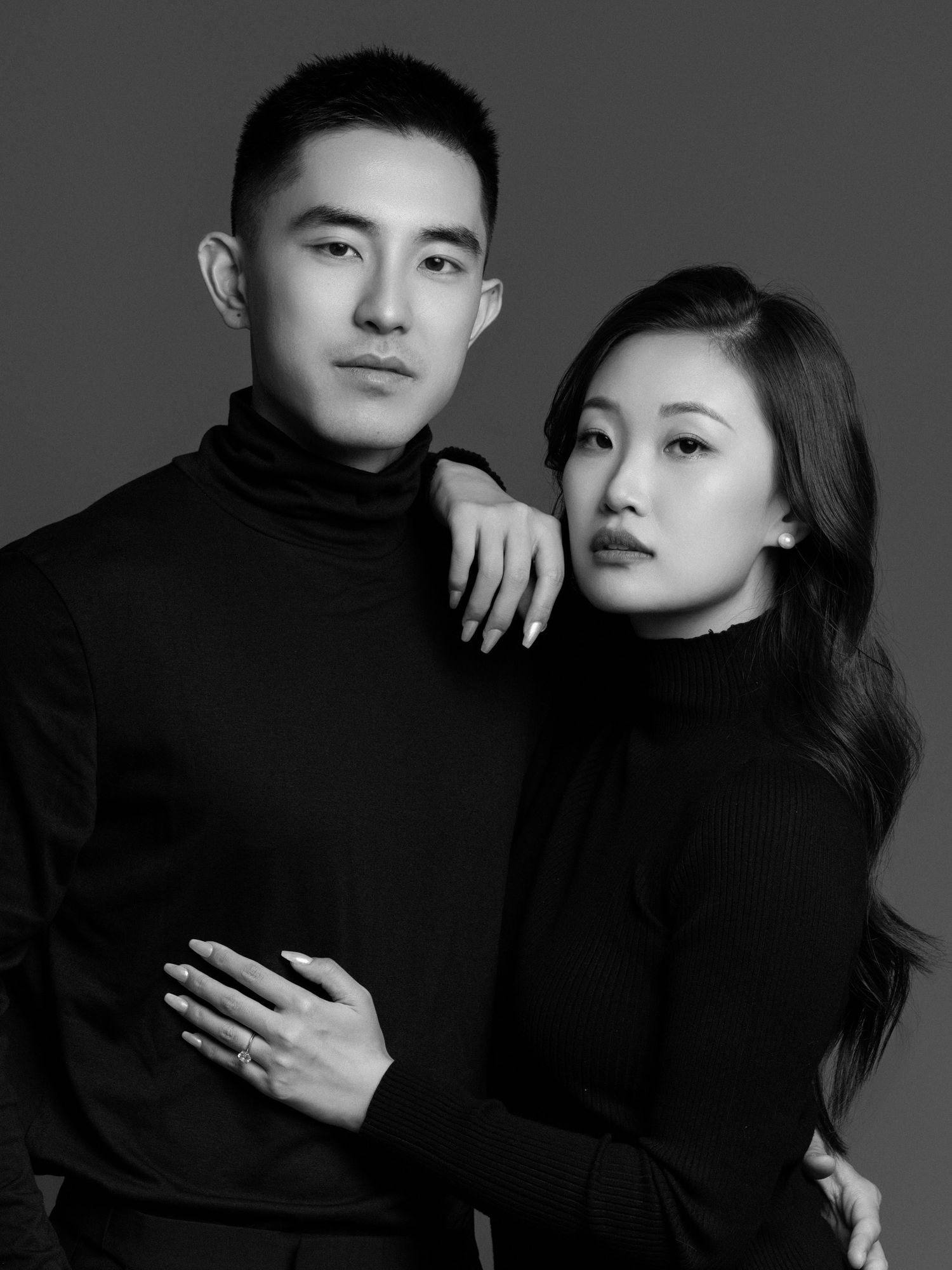 Minimalist portrait series in black turtlenecks against dark backdrop.
