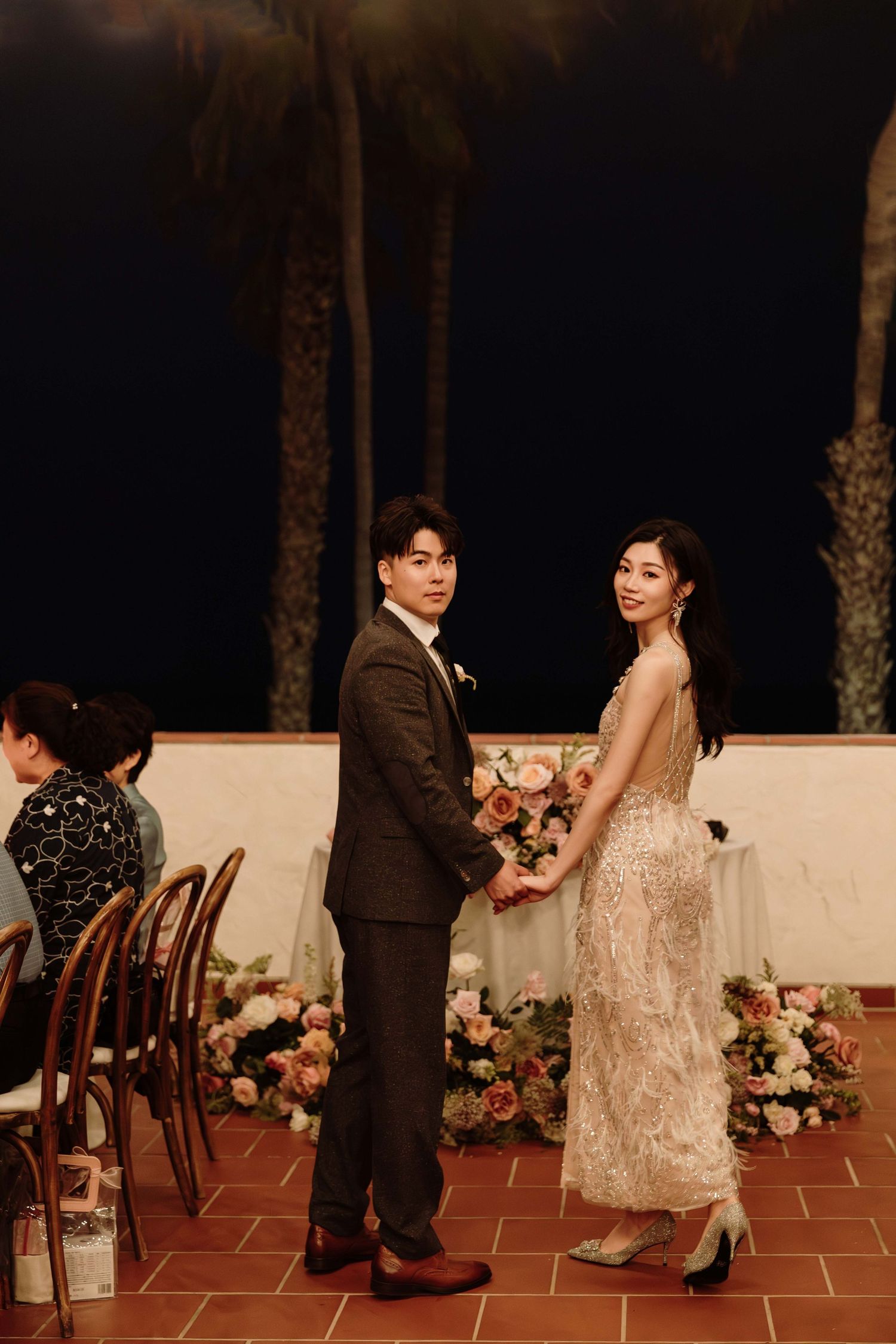Romantic evening wedding portraits on a Spanish-style terrace with floral decorations.