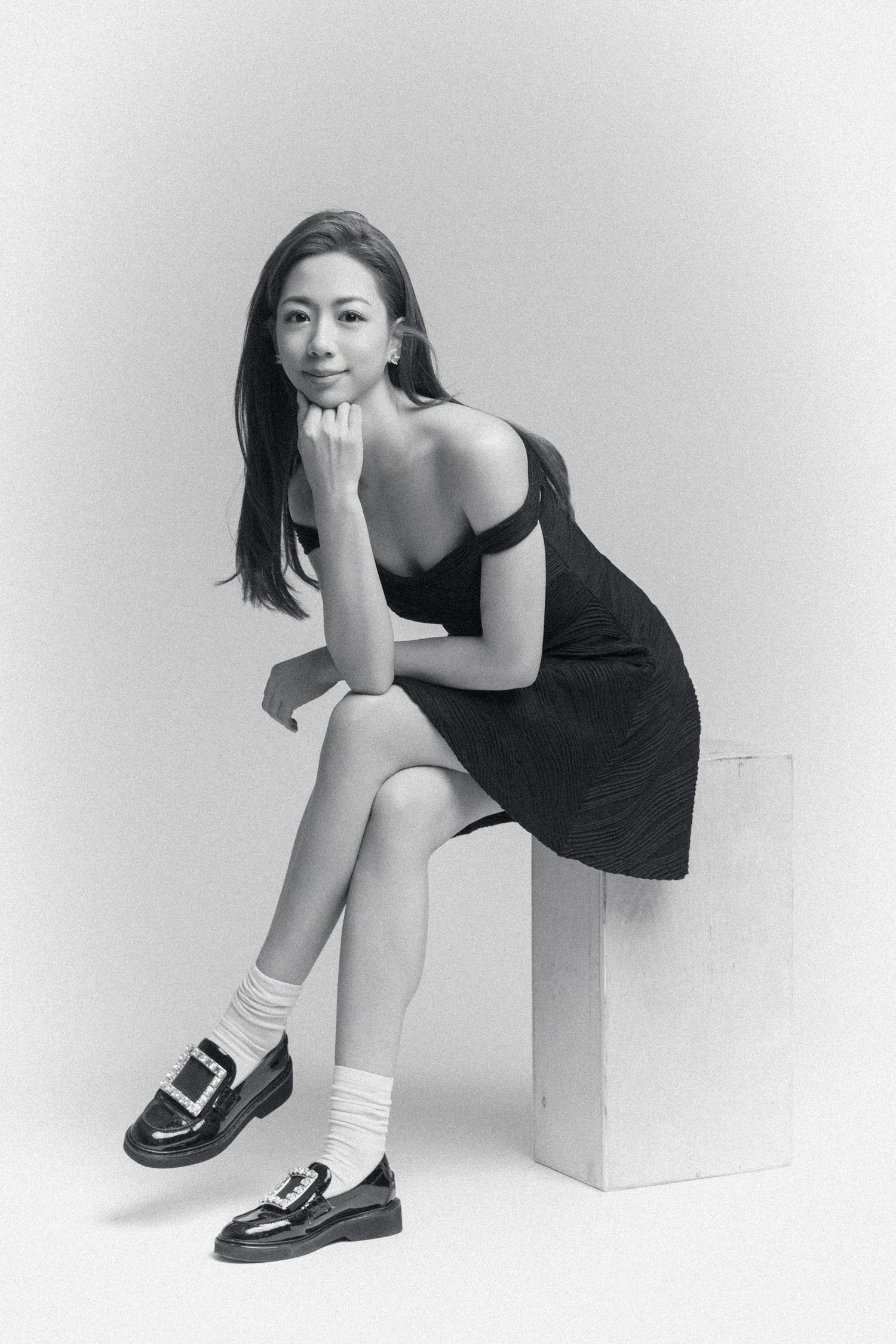 Artistic black and white studio portraits featuring model in black dress and white socks.