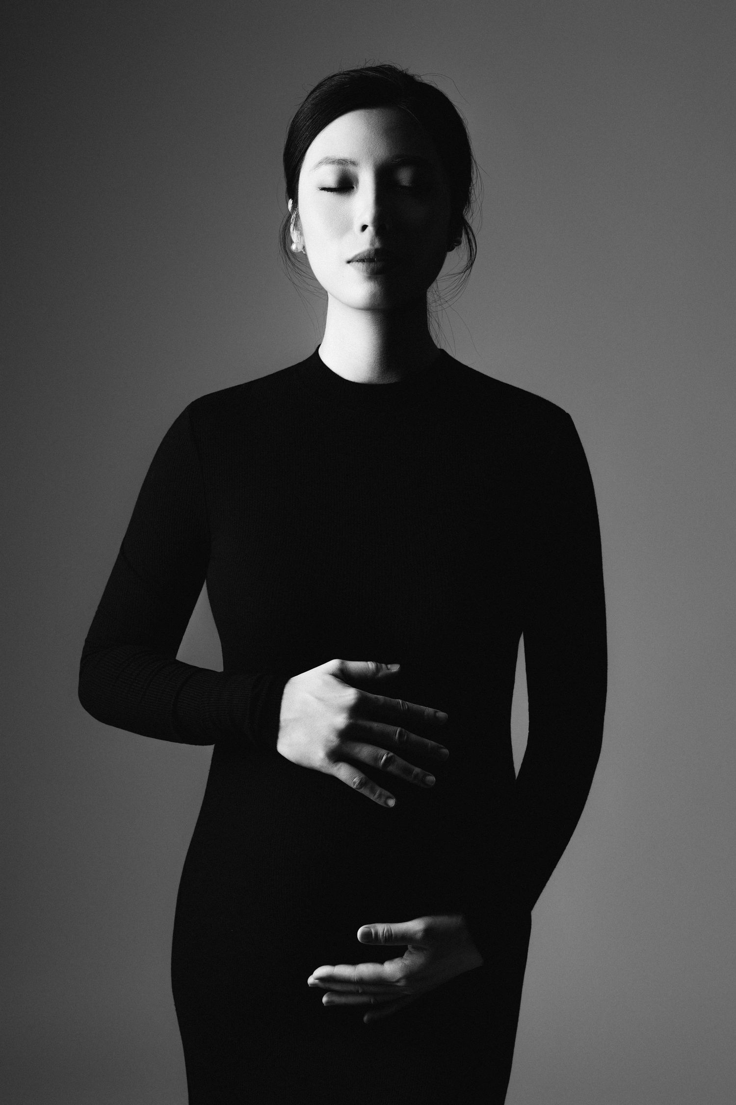 Dramatic black and white maternity silhouettes in dark clothing.